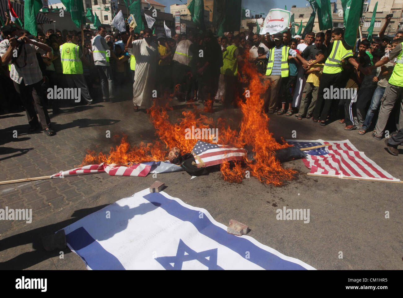 Sept. 14, 2012 - Gaza City, Gaza Strip, Palestinian Territory - Palestinians burn the Israeli and the U.S. flags during a demonstration against the controversial film 'Innocence of Muslims' in Khan Younis southern Gaza strip, on September 14, 2012. The controversial low budget film reportedly made by an Israeli-American which portrays Muslims as immoral and gratuitous, sparked fury in Libya, where four Americans including the ambassador were killed on Tuesday when a mob attacked the US consulate in Benghazi, and has led to protests outside US missions in Morocco, Sudan, Egypt, Tunisia and Yeme Stock Photo