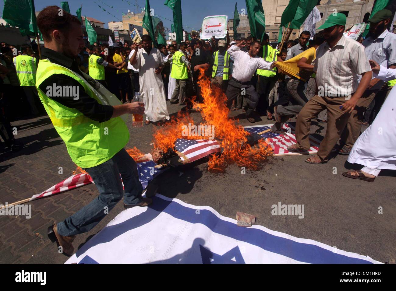 Sept. 14, 2012 - Gaza City, Gaza Strip, Palestinian Territory - Palestinians burn the Israeli and the U.S. flags during a demonstration against the controversial film 'Innocence of Muslims' in Khan Younis southern Gaza strip, on September 14, 2012. The controversial low budget film reportedly made by an Israeli-American which portrays Muslims as immoral and gratuitous, sparked fury in Libya, where four Americans including the ambassador were killed on Tuesday when a mob attacked the US consulate in Benghazi, and has led to protests outside US missions in Morocco, Sudan, Egypt, Tunisia and Yeme Stock Photo