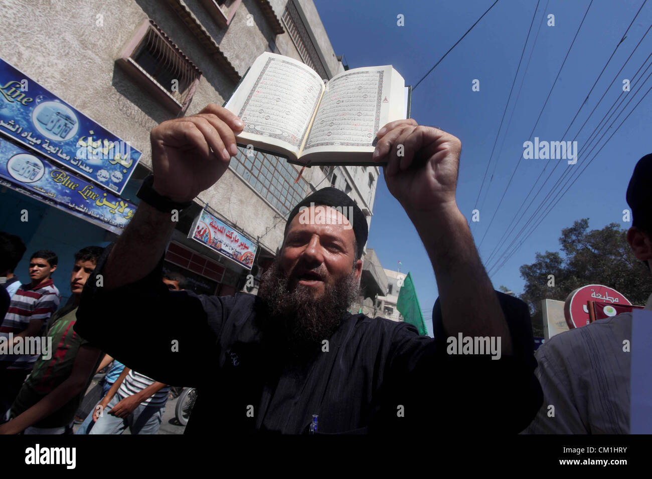 Sept. 14, 2012 - Gaza City, Gaza Strip, Palestinian Territory - A Palestinian man holds the holy Qur'an during a demonstration against the controversial film 'Innocence of Muslims' in Khan Younis southern Gaza strip, on September 14, 2012. The controversial low budget film reportedly made by an Israeli-American which portrays Muslims as immoral and gratuitous, sparked fury in Libya, where four Americans including the ambassador were killed on Tuesday when a mob attacked the US consulate in Benghazi, and has led to protests outside US missions in Morocco, Sudan, Egypt, Tunisia and Yemen  (Credi Stock Photo
