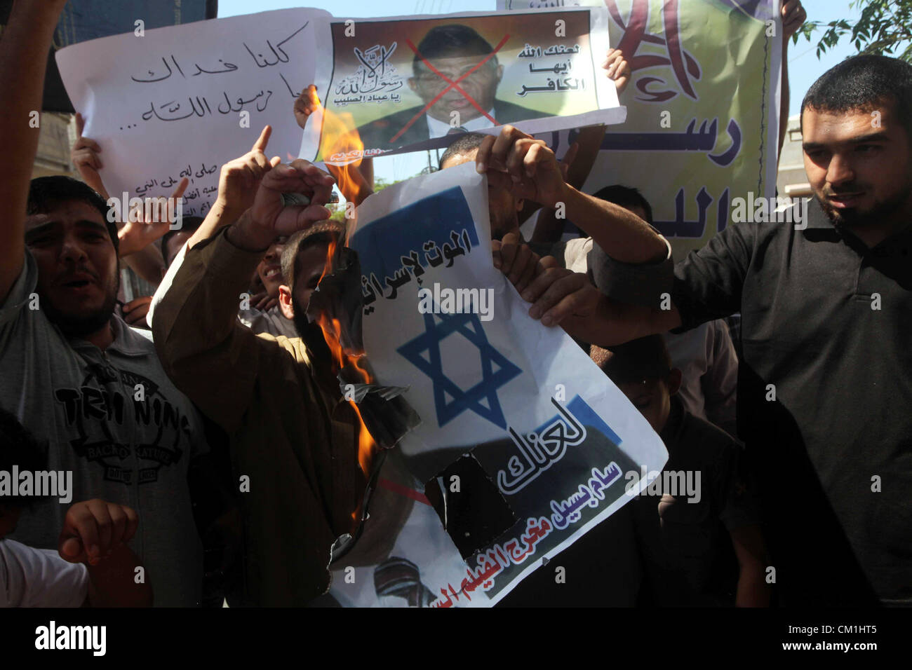 Sept. 14, 2012 - Gaza City, Gaza Strip, Palestinian Territory - Palestinians burn a portrait of the director of controversial film 'Innocence of Muslims' during a demonstration in Khan Younis southern Gaza strip, on September 14, 2012. The controversial low budget film reportedly made by an Israeli-American which portrays Muslims as immoral and gratuitous, sparked fury in Libya, where four Americans including the ambassador were killed on Tuesday when a mob attacked the US consulate in Benghazi, and has led to protests outside US missions in Morocco, Sudan, Egypt, Tunisia and Yemen  (Credit Im Stock Photo