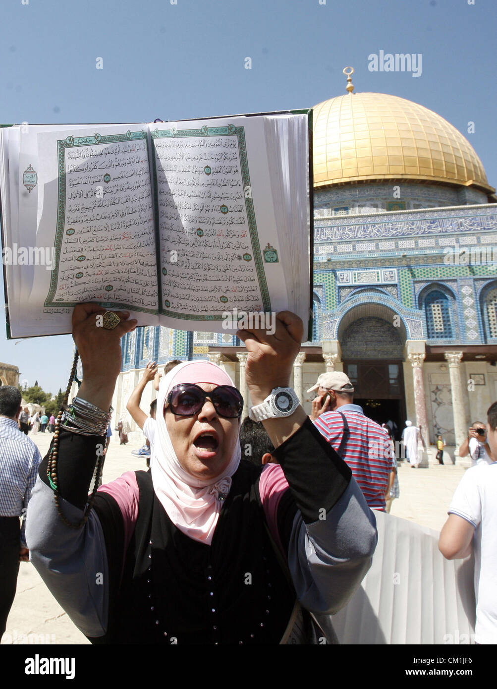 Sept. 14, 2012 - Jerusalem, Jerusalem, Palestinian Territory - A Palestinian woman holds up a copy of Holy Qur'an during a demonstration against the controversial film 'Innocence of Muslims' in front of al-Aqsa Mosqe in Jerusalem, on September 14, 2012. The controversial low budget film reportedly made by an Israeli-American which portrays Muslims as immoral and gratuitous, sparked fury in Libya, where four Americans including the ambassador were killed on Tuesday when a mob attacked the US consulate in Benghazi, and has led to protests outside US missions in Morocco, Sudan, Egypt, Tunisia and Stock Photo