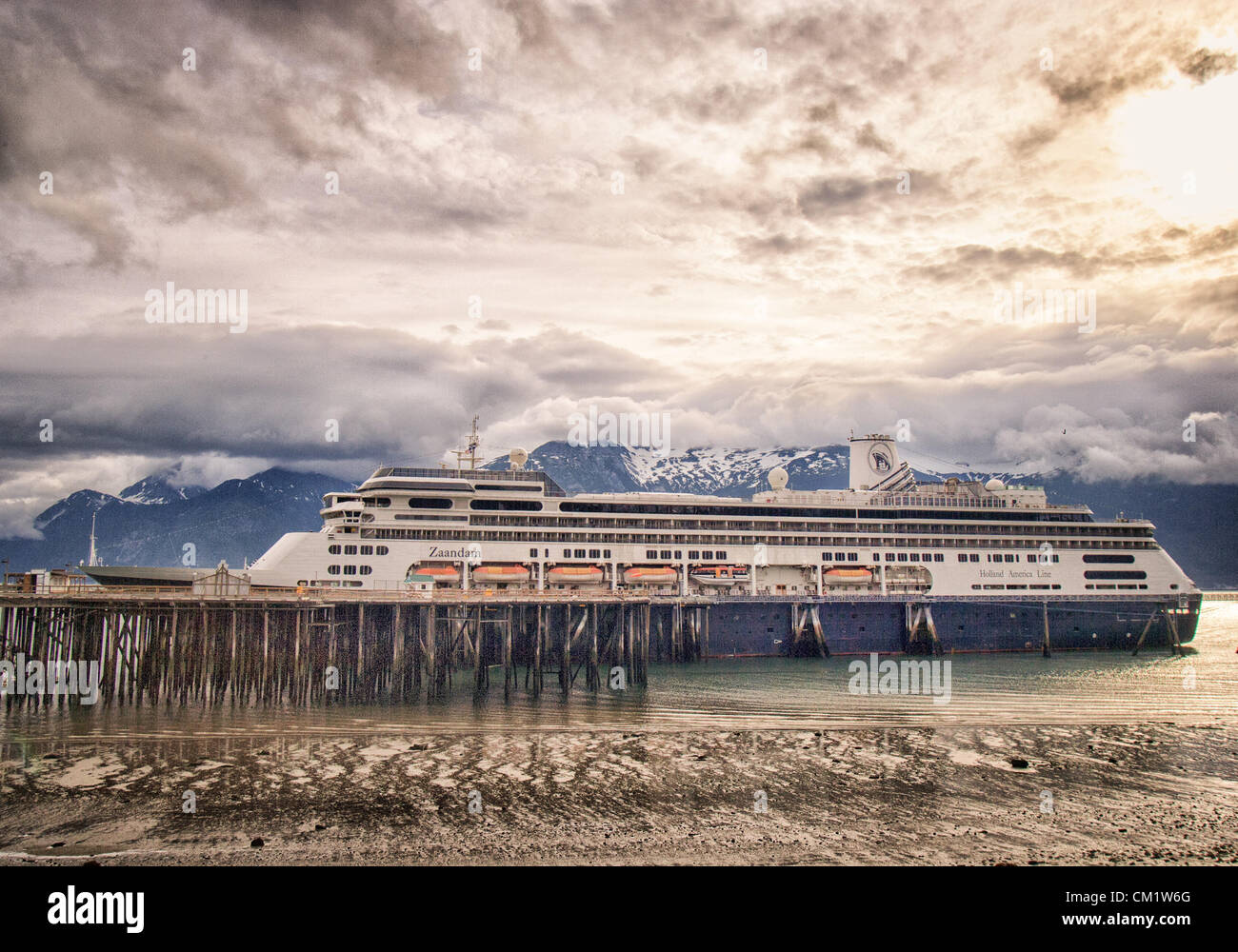 July 4, 2012 - Haines, Alaska, US - The ms Zaandam, a Holland America Line cruise ship, docked in Portage Cove at Haines, Alaska in early morning light. Dramatic clouds and the Chilkoot Mountain Range, part of the Coastal Range of mountains, form a spectacular backdrop. (Credit Image: © Arnold Drapkin/ZUMAPRESS.com) Stock Photo