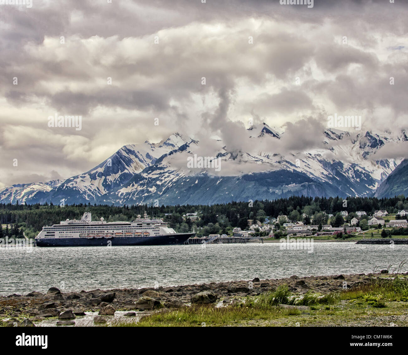July 4, 2012 - Haines, Alaska, US - The ms Zaandam, a Holland America Line cruise ship, docked in Portage Cove at Haines, Alaska, with dramatic clouds and the majestic Chilkat Mountain Range as a spectacular backdrop. (Credit Image: © Arnold Drapkin/ZUMAPRESS.com) Stock Photo