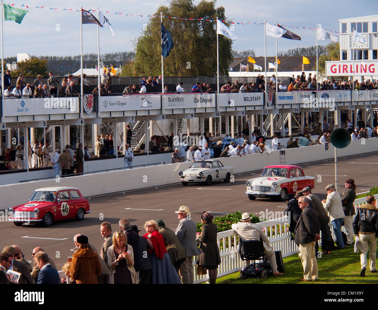 Goodwood Revival Practice Day Friday September 14th.2012. Three historic saloon racing cars approach the finishing line in front engineers and spectators in the pits. Stock Photo