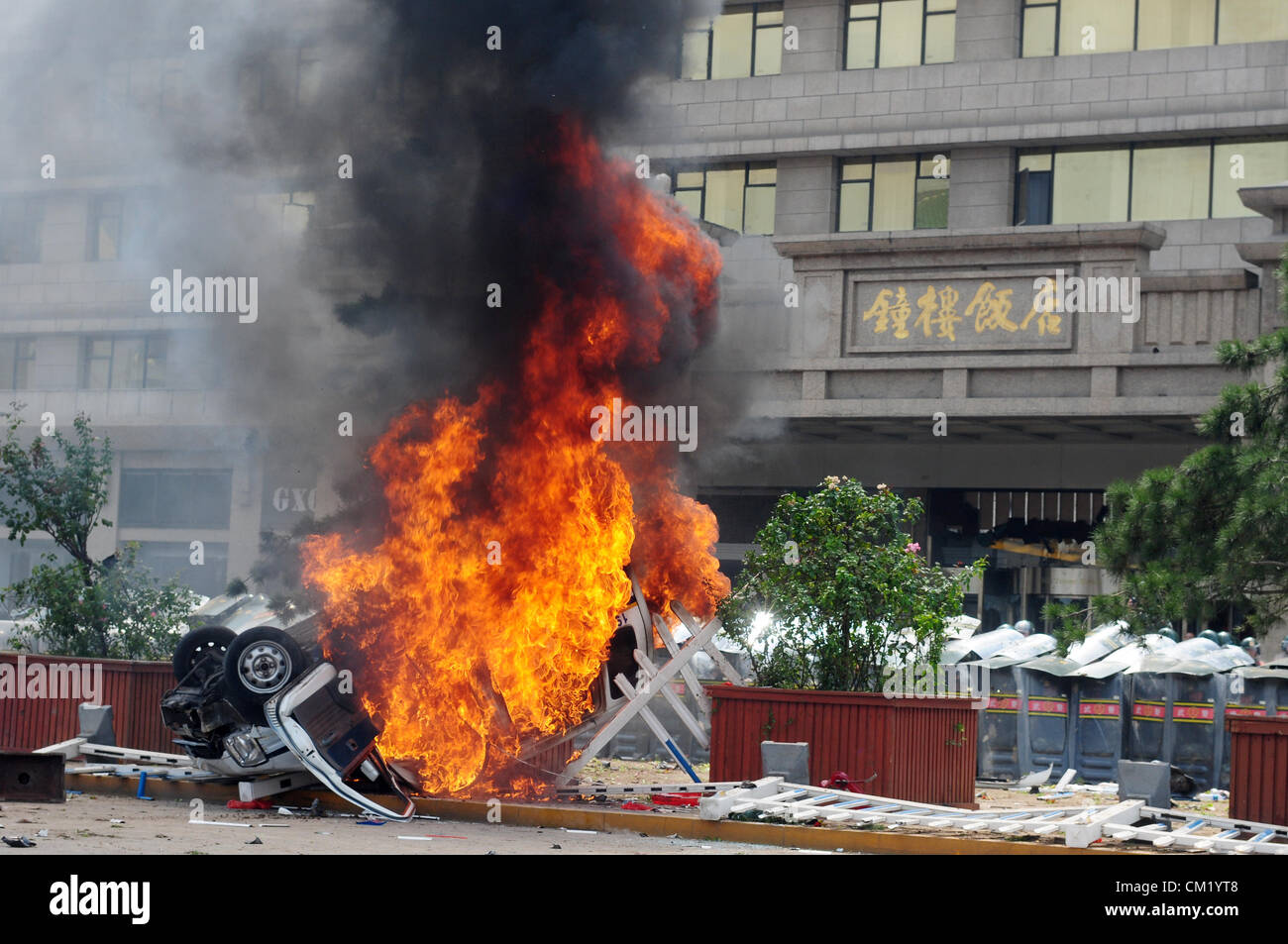 Xian, China. Saturday 15th September, 2012. Anti-Japanese protesters burn a car during a demonstration at Bell Tower Hotel in Xi'an,China,on Saturday Sept 15, 2012.  Fights broke out between demonstrators and police during a march by more than 10,000 students, who were protesting at the sovereignty of the Fishing Islands(Diaoyu Islands). Stock Photo