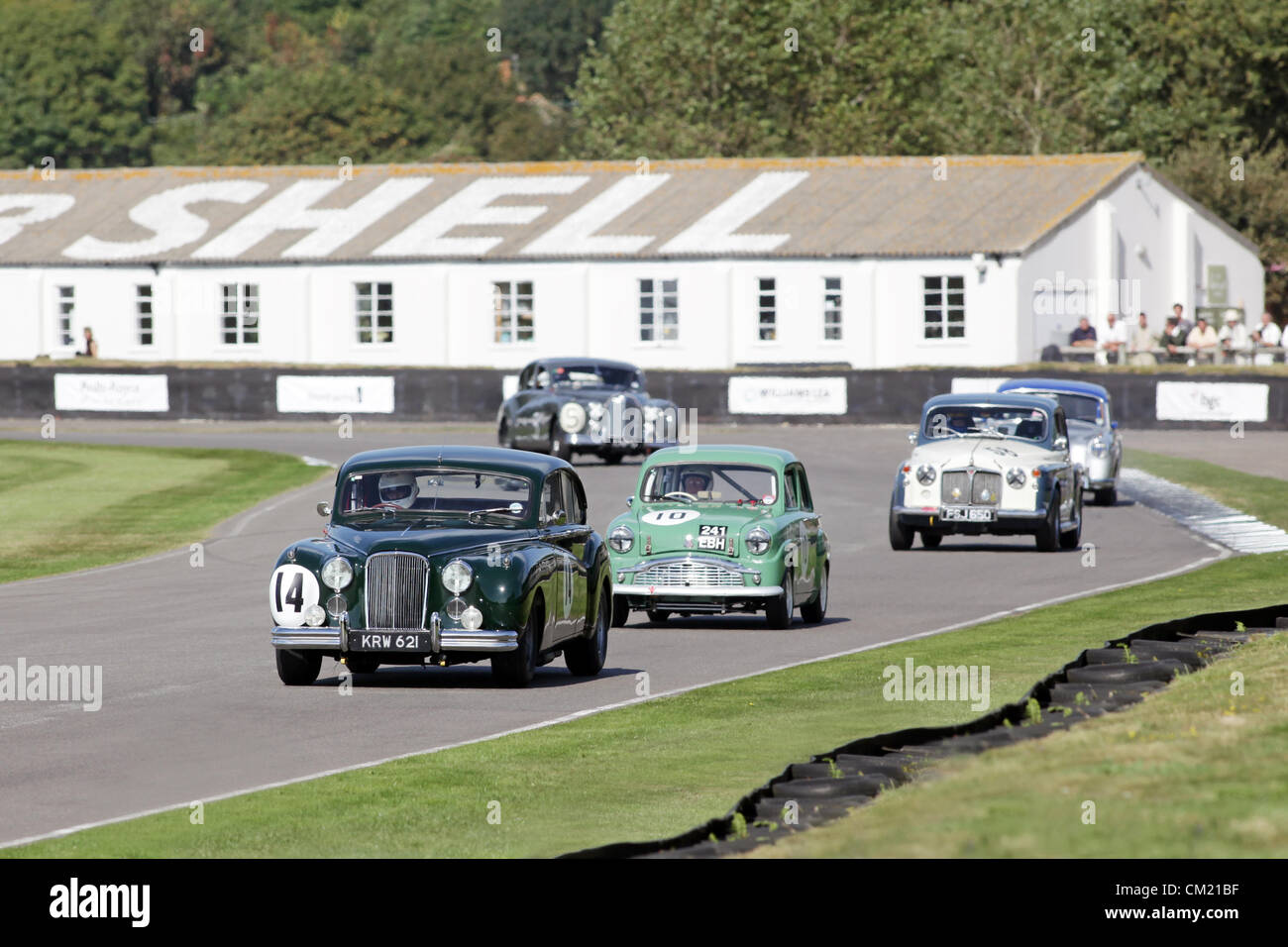 Goodwood Estate, Chichester, UK. 15th September 2012. Rowan Atkinson driving a Jaguar MkV11 is chased by Rauno Aaltonen in a Standard Ten during the St Mary's Trophy at the Goodwood Revival. The revival is a 'magical step back in time', showcasing a mixture of cars and aviation from the 40's, 50's and 60's and is one of the most popular historical motor racing events in the world. For more information visit www.goodwood.co.uk/revival. Stock Photo