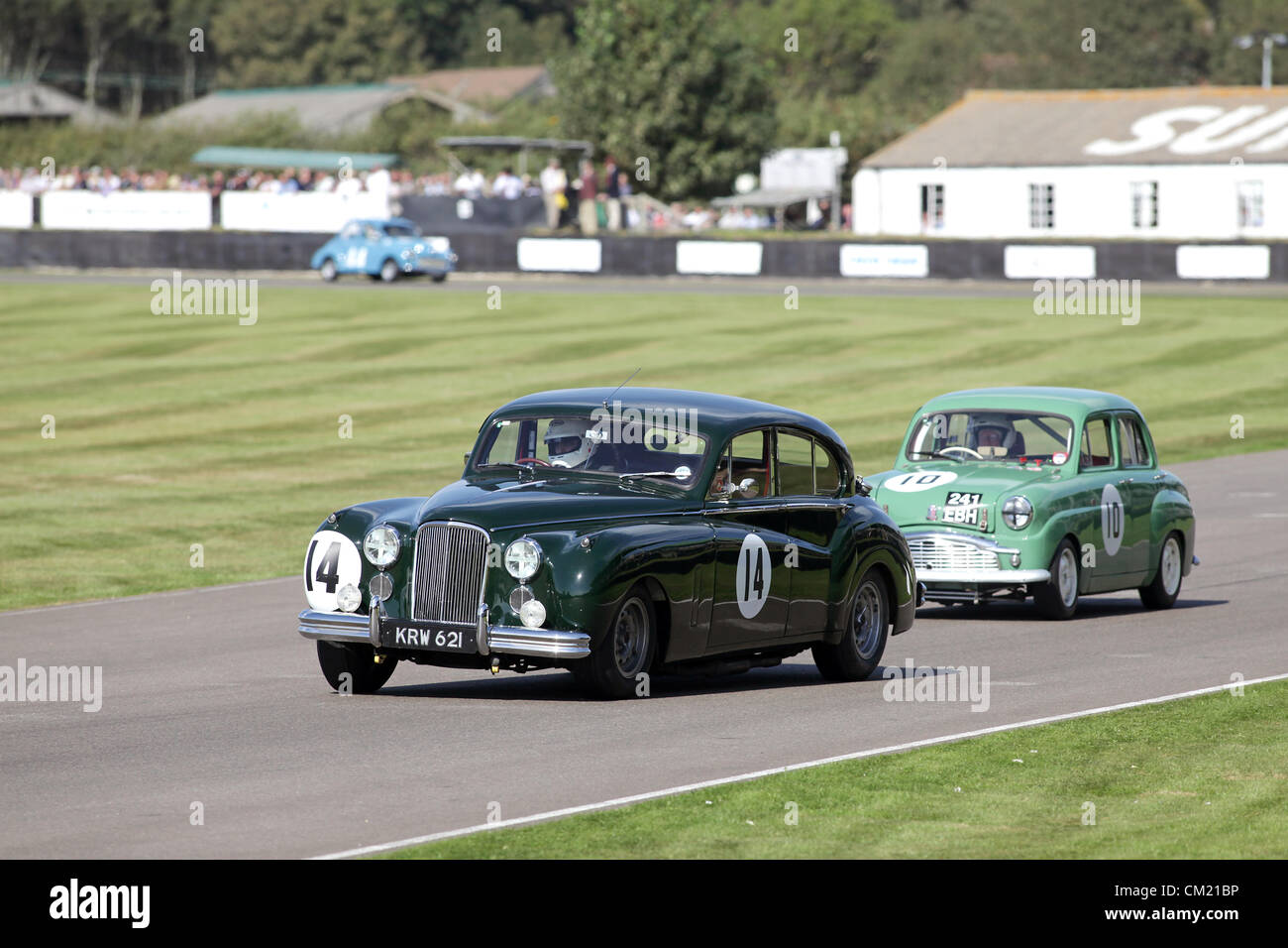 Goodwood Estate, Chichester, UK. 15th September 2012. Rowan Atkinson driving a Jaguar MkV11 is chased by Rauno Aaltonen in a Standard Ten during the St Mary's Trophy at the Goodwood Revival. The revival is a 'magical step back in time', showcasing a mixture of cars and aviation from the 40's, 50's and 60's and is one of the most popular historical motor racing events in the world. For more information visit www.goodwood.co.uk/revival. Stock Photo