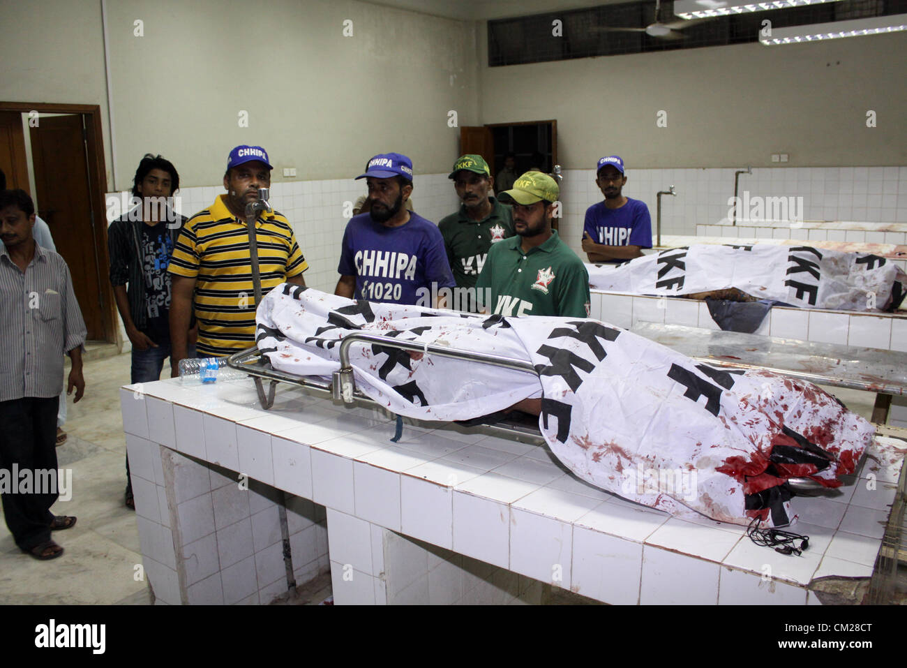 Rescue workers are gathered near the dead bodies of the blasts victims at local hospital in Karachi September 18, 2012. Atleast 8 people were killed while several others were injured when two planted bombs exploded. Stock Photo