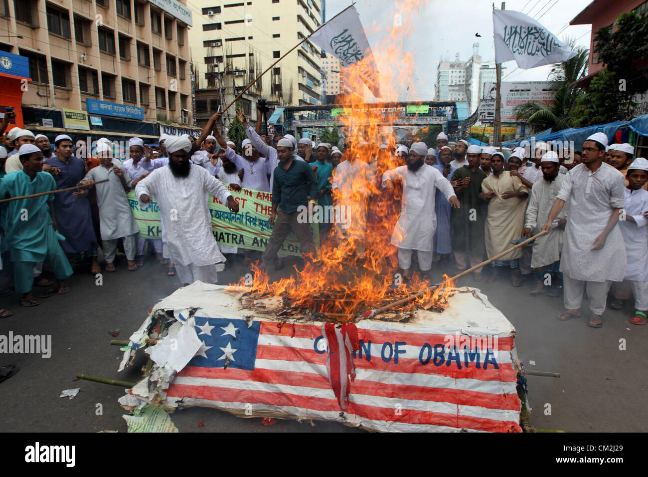 September 21, 2012 - Dhaka, Bangladesh. Bangladeshi Muslims burn a U.S. and French flag and a mock coffin of US President Obama during a protest in Dhaka. Hundreds of Muslims took part in the protest some waving religious flags. They chanted 'Death to the United States and death to France'. The protest is against the anti-Islam movie and cartoon published in a French magazine.  Stock Photo