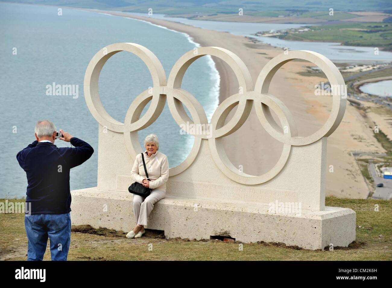 Dorset's Olympic rings given pride of place at the popular viewpoint above Chesil Beach on Portland. One of the most top rated coastal views in Britain has been enhanced with the placing of a set of carved Portland Stone Olympic rings at the popular viewpoint above Chesil Beach in Dorset.  The Olympic organisers have given the Borough of Weymouth and Portland special permission to have on permanent display the stone olympic rings to mark the fact that the town was a 2012 venue for the London Games. Displaying the Olympic rings symbols is very strictly controlled and the organisers gave their b Stock Photo