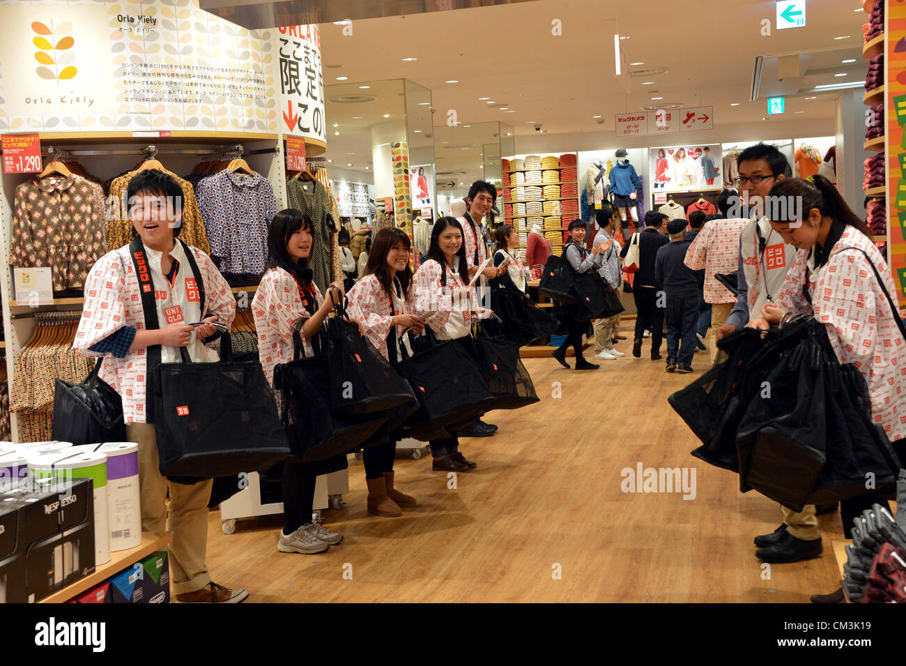 September 27, 2012, Tokyo, Japan - Staff members in new uniform greet frist  bach of customers at the grand opening of BicQlo, a collaboration of casual  clothing retailer Uniqlo and consumer electronics