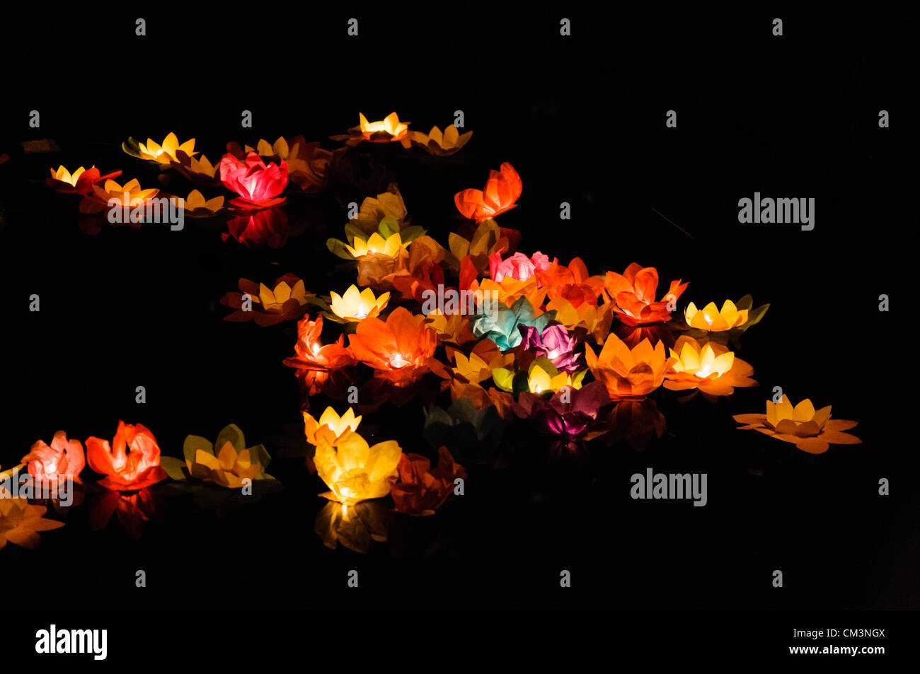 Paper lotus flowers with candles float on a river at night to mark the Chinese Mid-Autumn Festival Stock Photo