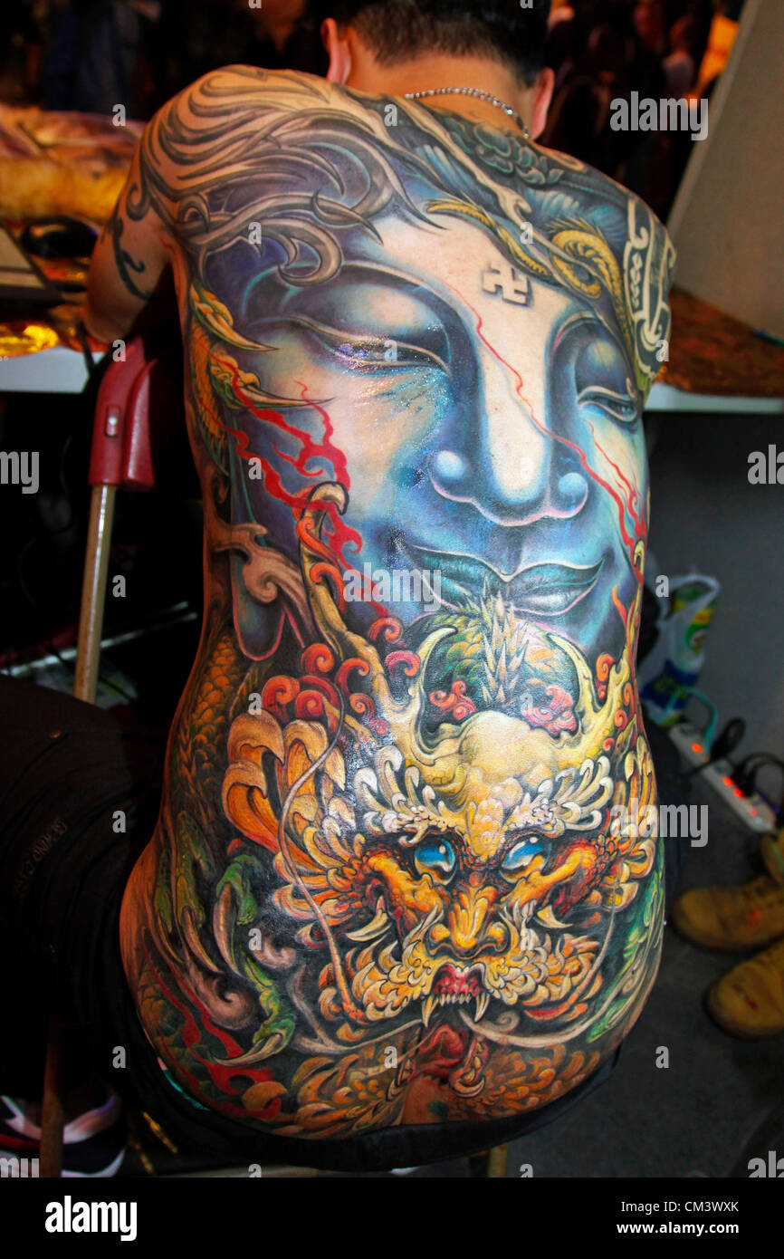 London, UK. 28th September 2012. Tattooist Gao Bin of Lion King Tattoo from Taiwan tattooing at the London Tattoo Convention 2012 Stock Photo