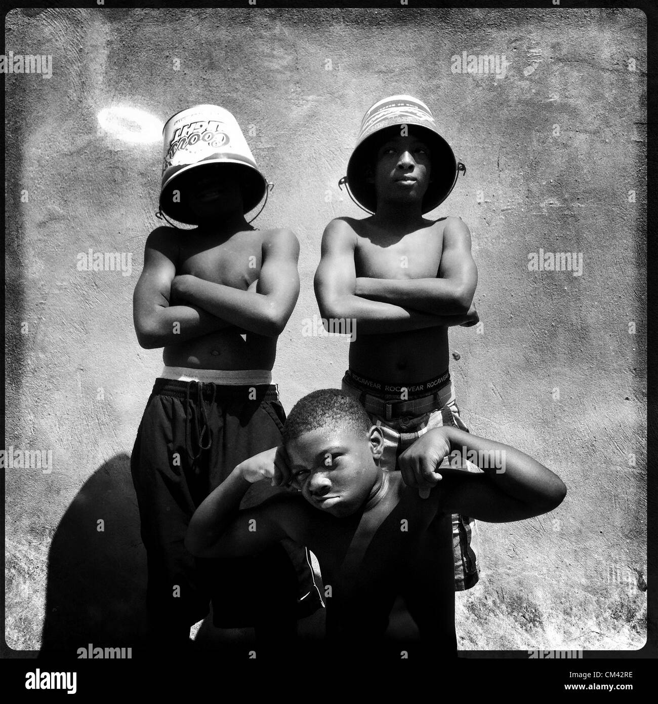 June 16, 2012 - Memphis, TN, U.S. - Flippers, left to right, Avalanche Wallace, 9, Eric Bonds, 9, and Keyshawn Henry, 12, learn to make money using their acrobatic skills and tip buckets daily on Beale Street. The children help to support their families. Flexing, Bonds says, ''Look how my arms is. I'm gonna be built.'' His uncle founded the Beale Street Flippers...Chris Dean observes: ''To have someone by your side to say this is how it's done...someone to look up to. Not just flipping but in every step of lifeÃ‰ someone to say don't make the next right because that's one of the mistakes I mad Stock Photo