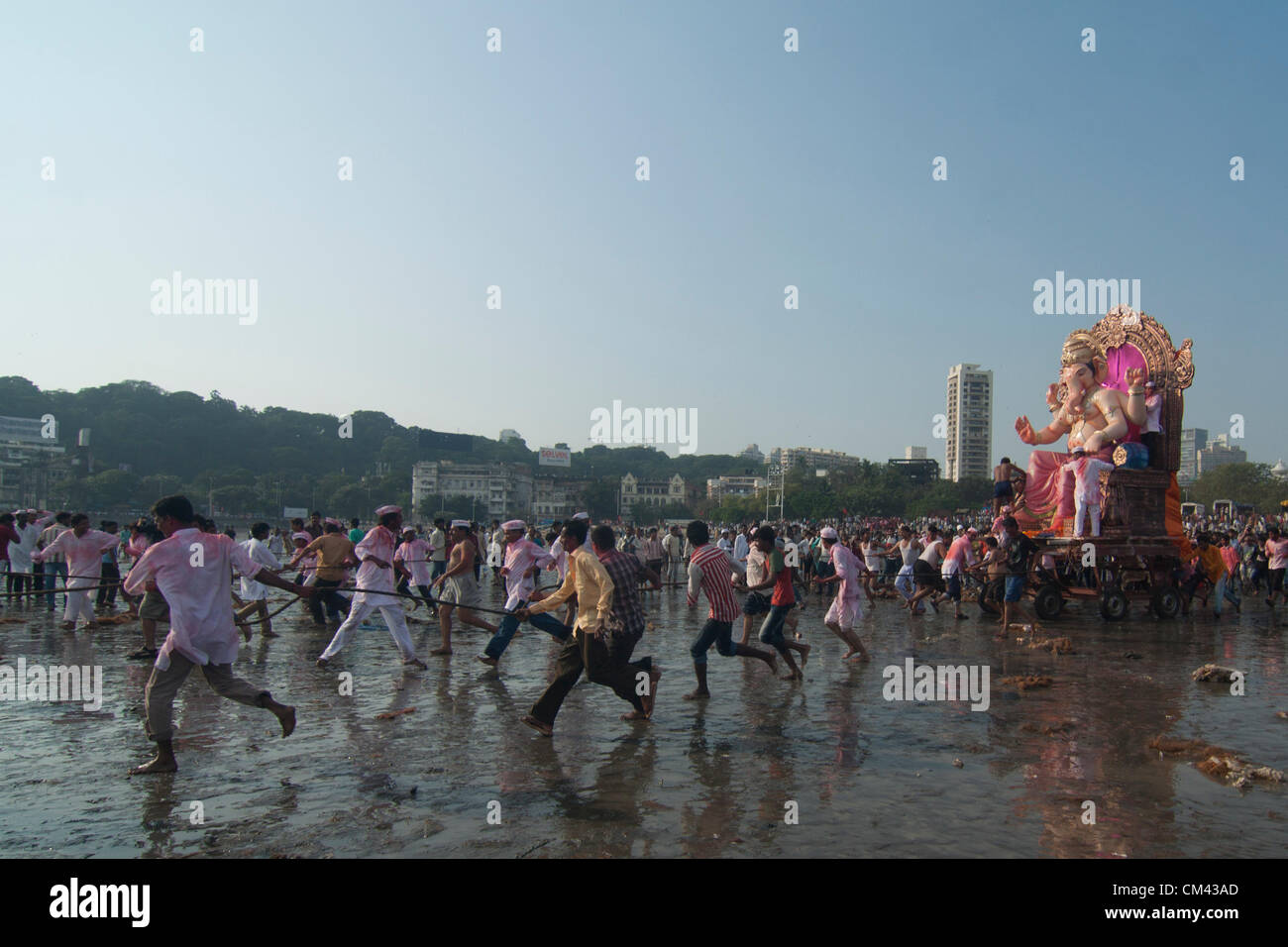 Mumbai, India. Indian Hindu devotees carry around a huge idol of the elephant-headed Hindu god Lord Ganesha on the beach for immersion of the idol into the Arabian Sea of Mumbai on September 29, 2012. People celebrate Ganpati (rebirth) of Lord Ganesh the Elephant God. Lasting for 10days, this custom culminates with the ritual emersion of Ganesh idols in local rivers and lakes. Stock Photo