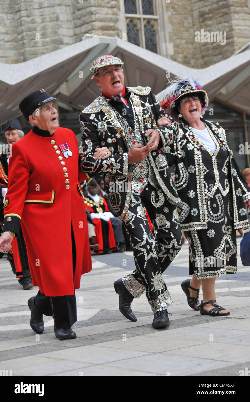 Guildhall Yard, London, UK. 30th September 2012. Pearly Kings & Queens and a Chelsea Pensioner. The Pearly Kings and Queens Harvest Festival in Guildhall Yard. A Cockney annual event with Maypole Dancers, Morris Men, a marching band and Pearly Kings & Queens from all over London. Stock Photo