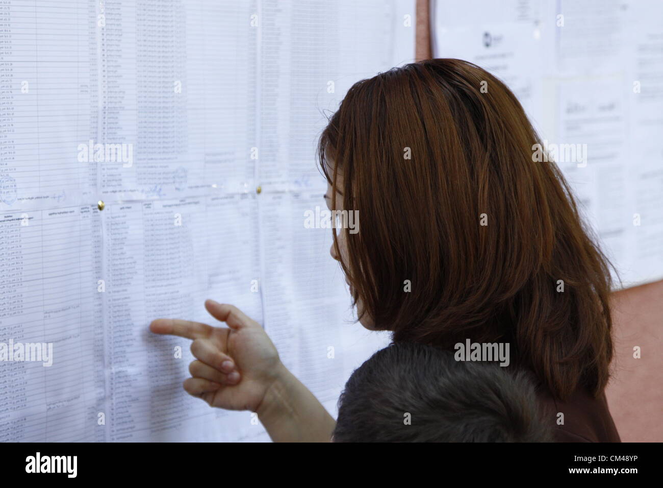 1 October 2012 - Tibilisi, Georgia - A young woman trying to find her name on the voters list outside of polling station 54 in Tibilisi's Vasha Pshavela district. Credit:  Johann Brandstatter / Alamy Live News Stock Photo