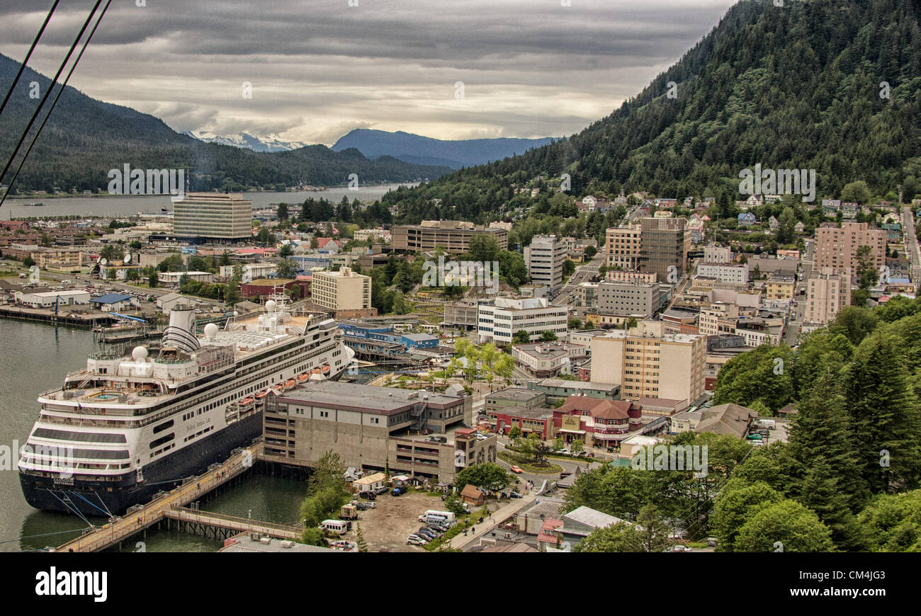 July 5, 2012 - Borough Of Juneau, Alaska, US - Juneau, the Capital of Alaska, seen from a gondola of the Mt Roberts Tramway looking North. The city sits on the Gastinaeau Channel with the Chilkat Mt Range and Glacier Bay National Park in the distance. At left, mountainous, forested Douglas Island is connected to the Juneau mainland by the Juneau-Douglas Bridge. At right the lower slopes of Mt Juneau. Left foreground is the Holland Americas Line ms Zaandam. the cruise ship industry is a large contributor to the local economy. (Credit Image: © Arnold Drapkin/ZUMAPRESS.com) Stock Photo