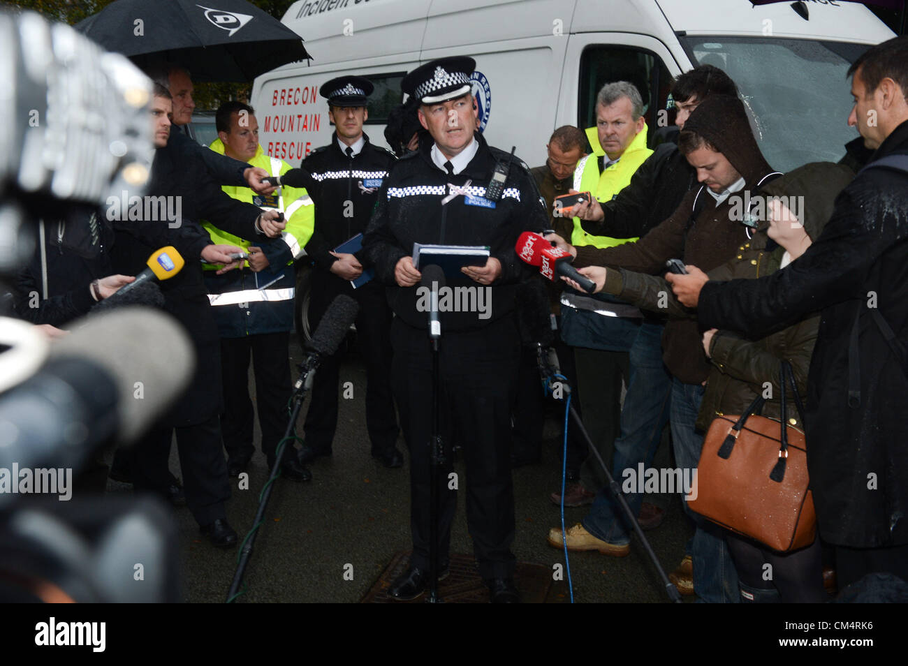 Machynlleth, Powys, Wales, UK. 4th October 2012. Superintendent IAN JOHN gives a press conference in the rain outside the leisure centre that has been the focus for community volunteers and rescue workers in the search for missing 5 year old girl APRIL JONES. On the fourth night after her abduction police are redoubling their efforts to find the child.  photo Credit: keith morris/Alamy Live News Stock Photo