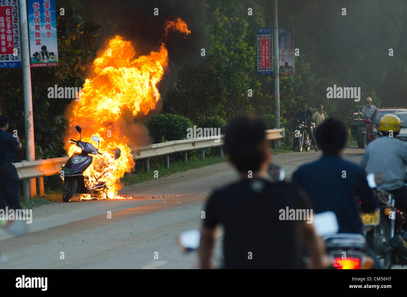 A petrol driven scooter burns out of control at the roadside of the G301 in Eastern Hainan. Vehicle and road safety have come under renewed scrutiny in recent weeks after a two buses have crashed  and burned on separate occasions killing over 40 people in other parts of China. © Olli Geibel Stock Photo
