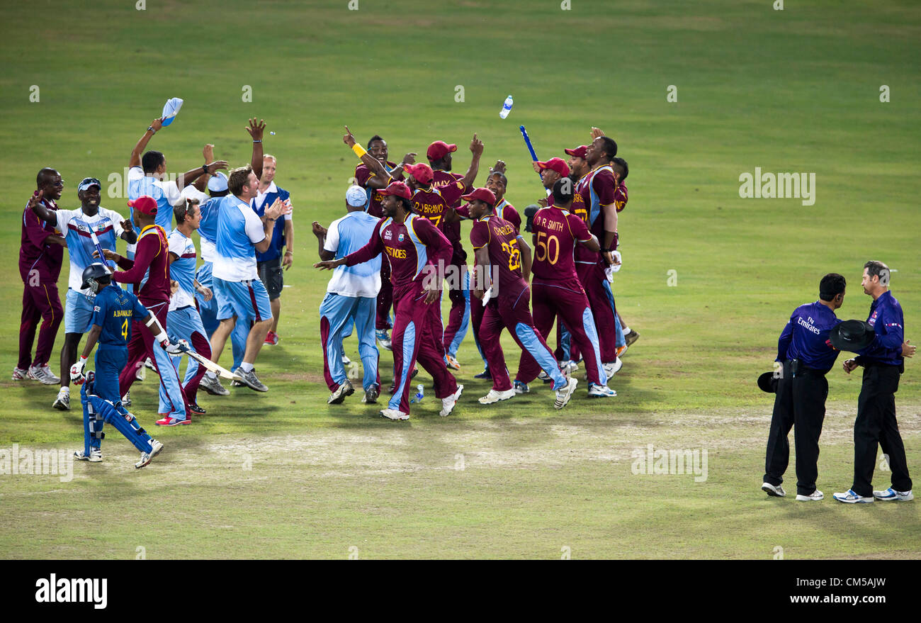 The celebration continues with bottles flying while the two umpires congratulate each other at the culmination of a successful World Cup Stock Photo