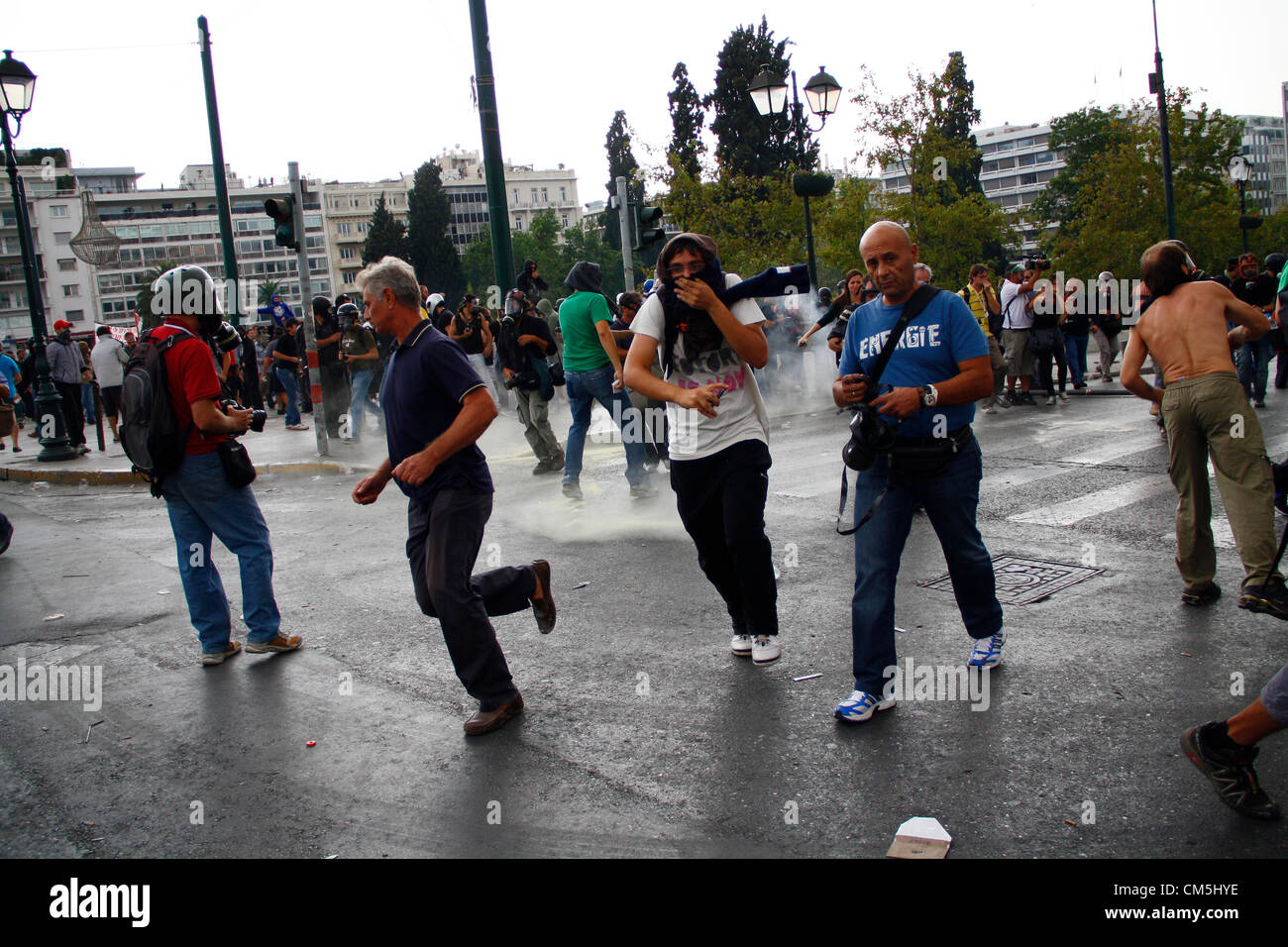 Athens, Greece. 9th October 2012. Protesters run away from tear gas bomb explosion. Violent clashes took place during an anti-Merkel protest as German Chancellor visited Athens in 9th October 2012. Stock Photo
