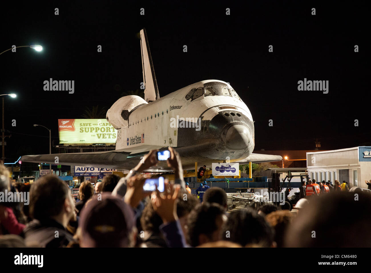 Inglewood, Los Angeles, CA, USA- 12 October, 2012 - The Space Shuttle Endeavour is towed through the streets of Los Angeles on its way to its permanent home at the California Science Center, making a nighttime stop at La Cienega and Manchester Blvd where a Toyota Tundra truck will replace the heavier transport to tow it across the bridge over the 405 Freeway. The Shuttle was decommissioned in 2011 when the NASA space program was discontinued. Stock Photo