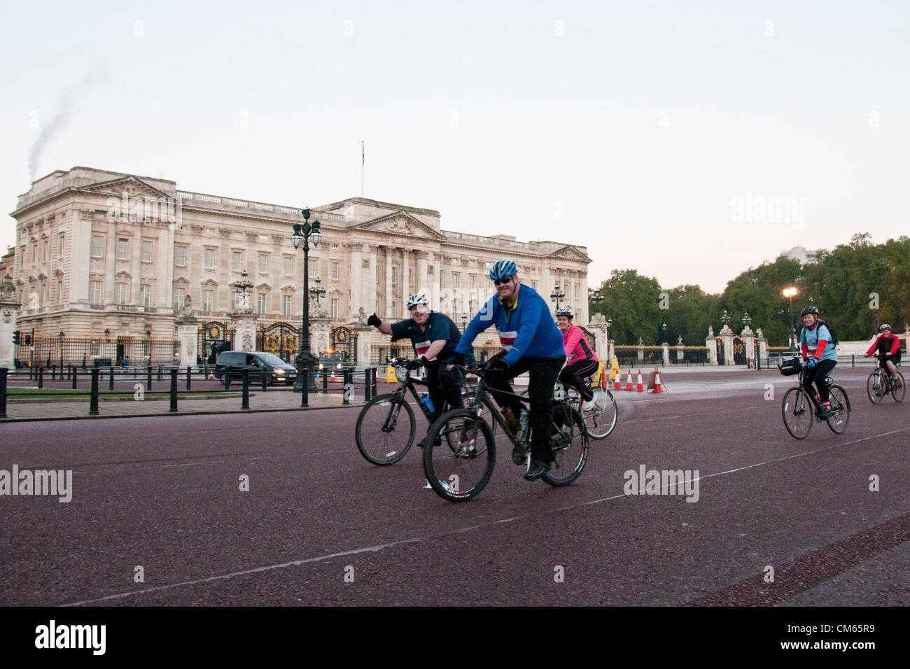 London, UK. 14/10/12. Cyclists pass Buckingham Palace at the beginning