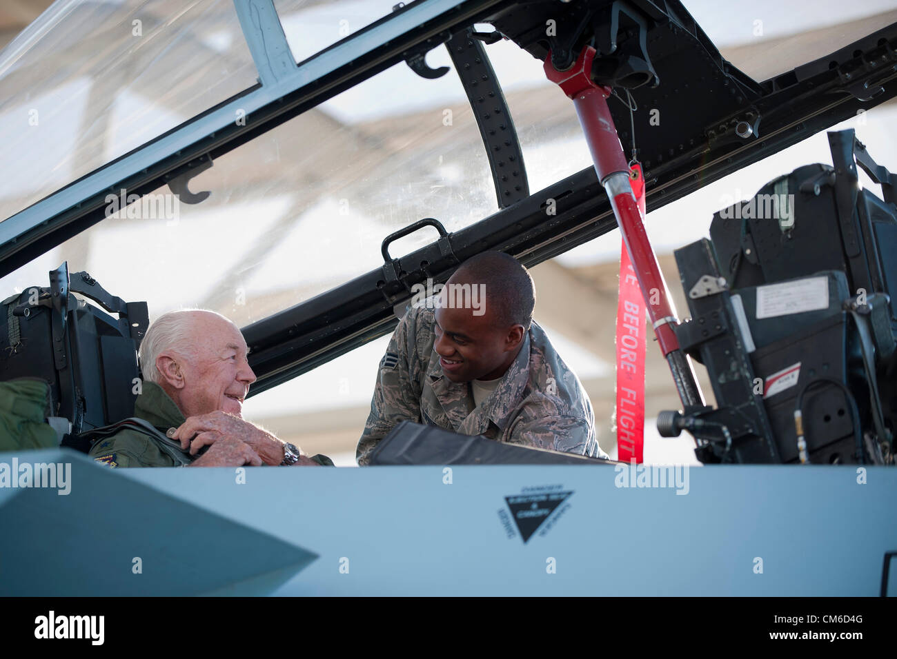 Retired United States Air Force Brig. Gen. Chuck Yeager, 89, is assisted in the cockpit of an F-15D Eagle by Senior Airman Anthony Ewin before taking off to celebrate the 65th anniversary of becoming the first person to break the sound barrier October 14, 2012, at Nellis Air Force Base, Nevada. In 1947 Yeager broke the sound barrier in a Bell XS-1 rocket research plane named Glamorous Glennis. Stock Photo
