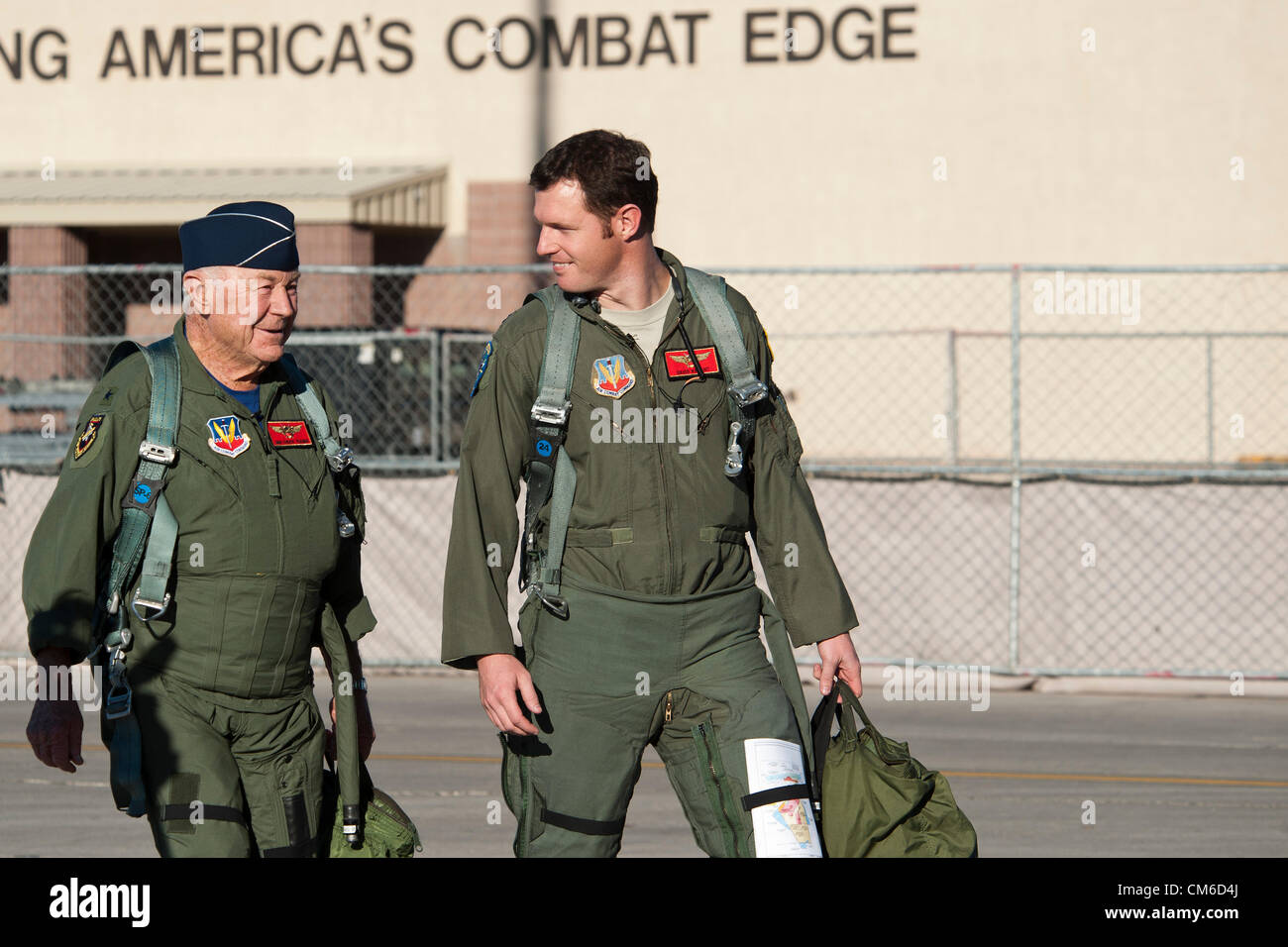 Retired United States Air Force Brig. Gen. Chuck Yeager, 89, and Air Force pilot Capt. David Vincent walk to their F-15D Eagle fighter aircraft to celebrate the 65th anniversary of becoming the first person to break the sound barrier October 14, 2012, at Nellis Air Force Base, Nevada. In 1947 Yeager broke the sound barrier in a Bell XS-1 rocket research plane named Glamorous Glennis. Stock Photo