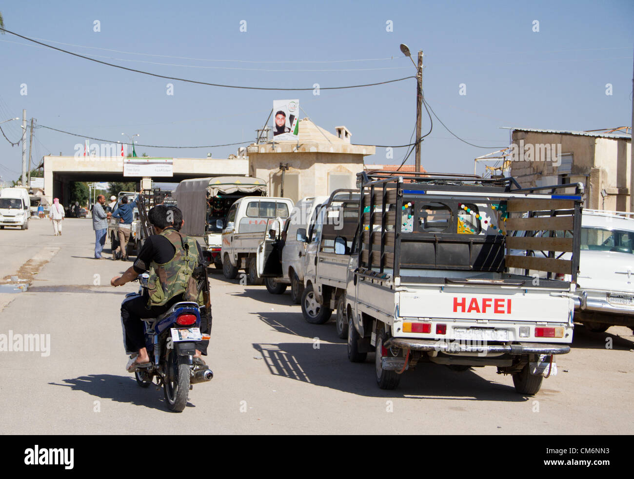 Azaz, Syria. 17th October 2012. Men ride past cars at the Syrian border post with Turkey in A'zaz, Syria on October 17, 2012. Stock Photo