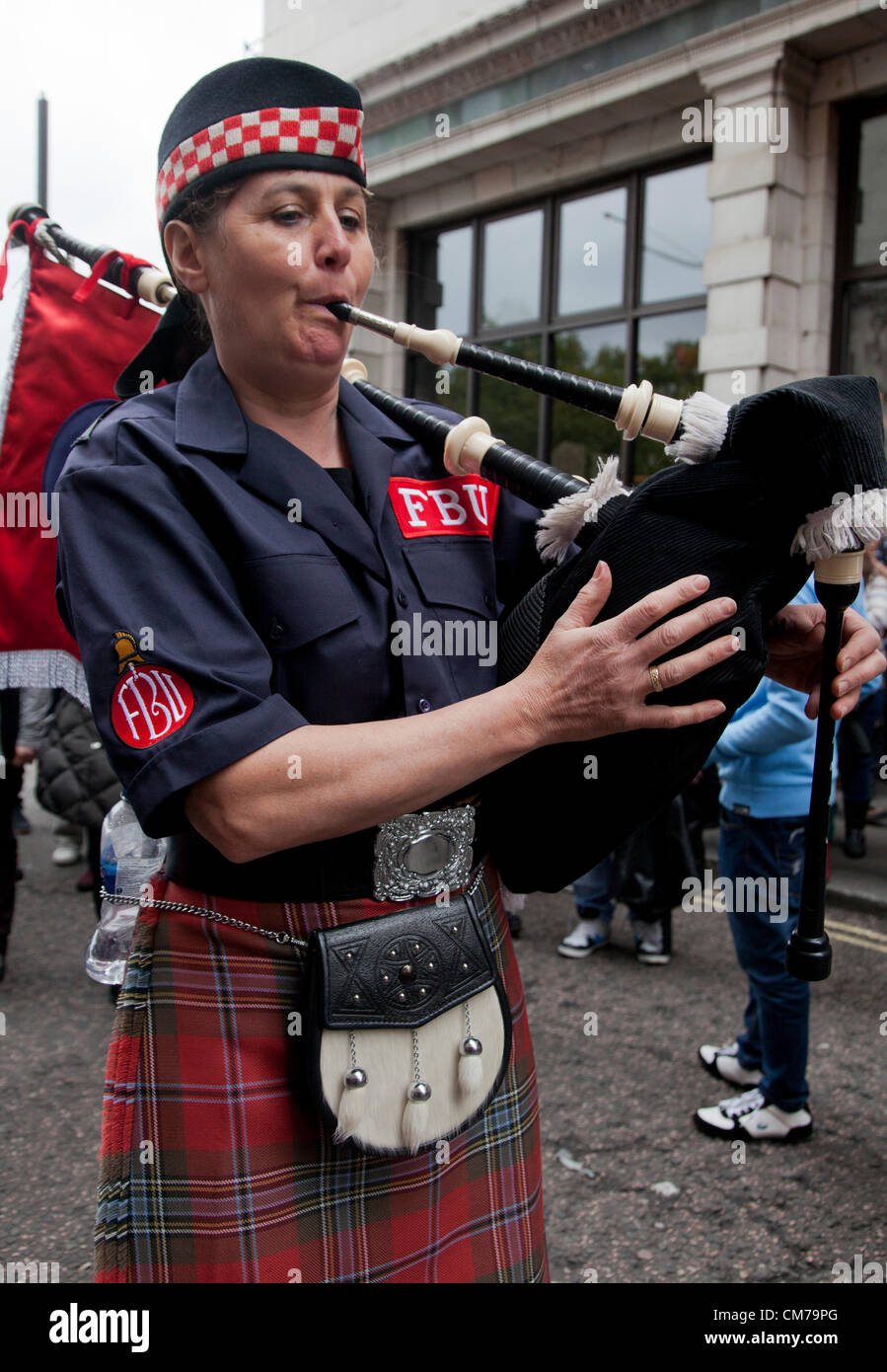 Scottish woman Fire Brigade Union member play bagpipe during Trade Unions' Coalition for Resistance anti-cuts rally in London Stock Photo
