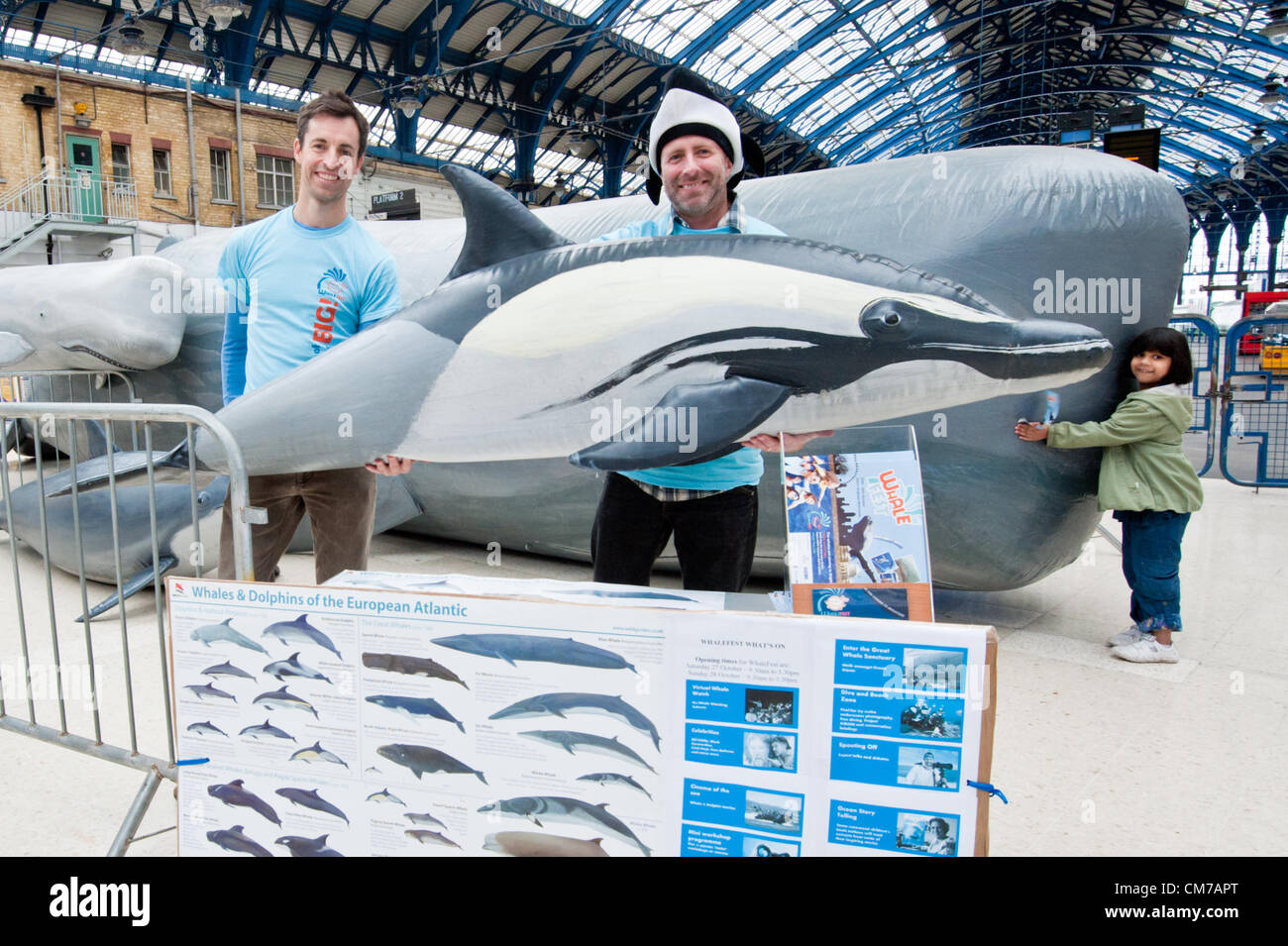 Brighton, UK. 21st October, 2012. Co founders of Whalefest Dylan Walker and Ian Rowlands with a common dolphin and the Whale now standing at platfroms 1,2,and 3 of Brighton Station is a 13 metre female Sperm Whale. She, her calf and friends will be arriving at Whalefest at Brighton Hilton Metropole on 27th and 28th October 2012. phot Credit: Julia Claxton/Alamy Live News Stock Photo