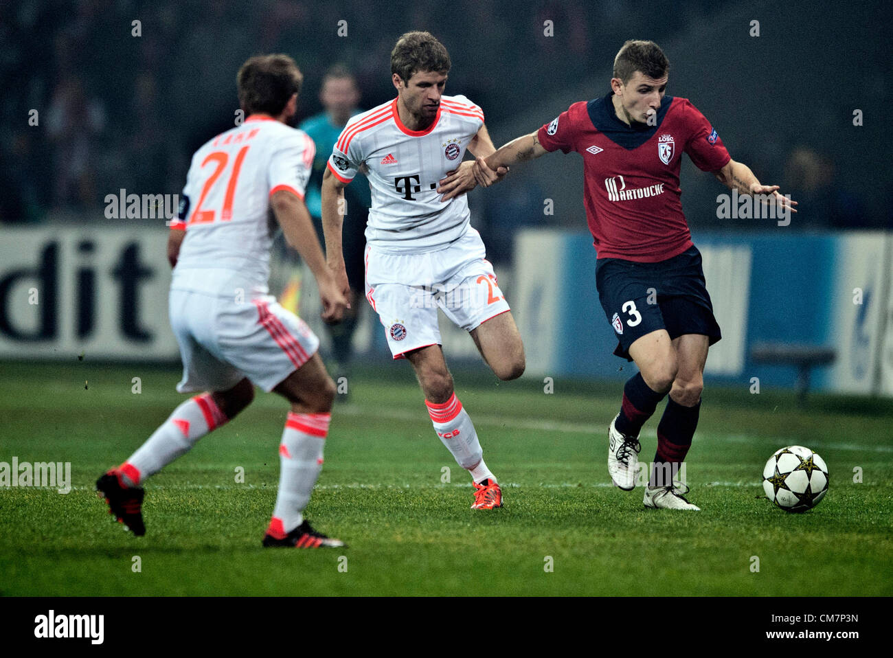 23.10.2012. Lille, France.  Munich's Thomas Mueller (C) runs with the ball against Lille's Lucas Digne (R) during the Champions League Group F soccer match between OSC Lille and FC Bayern Munich at the Grand Stade Lille Metropole in Lille, France. Stock Photo