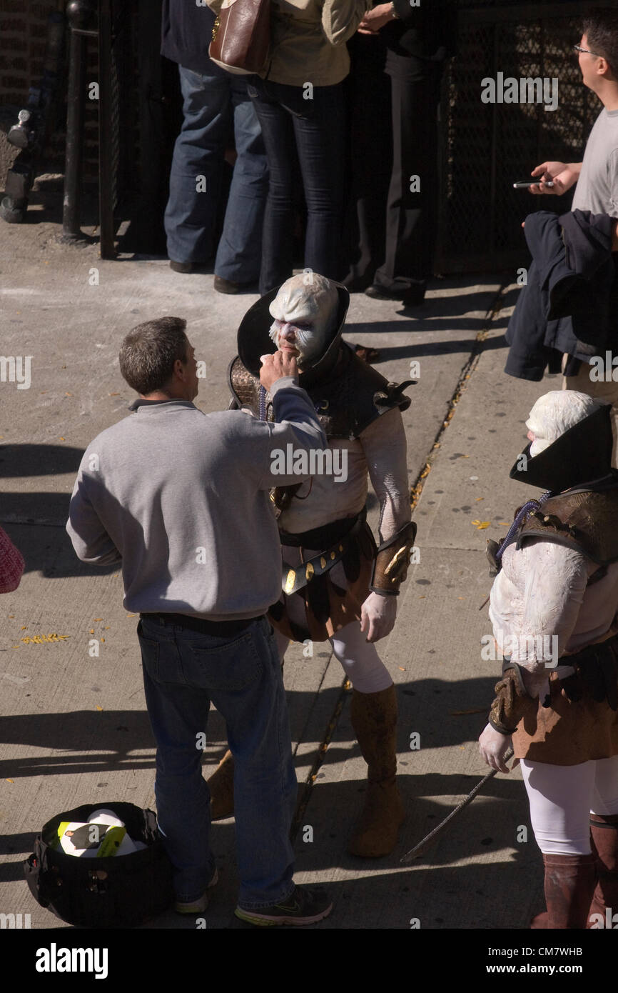 New York, USA. October 22nd 2012. O Positive Films. Two actors dressed as Aliens getting their makeup touched up in between takes from filming a movie on Wadsworth Avenue in the Inwood neighborhood of Manhattan in New York City Stock Photo