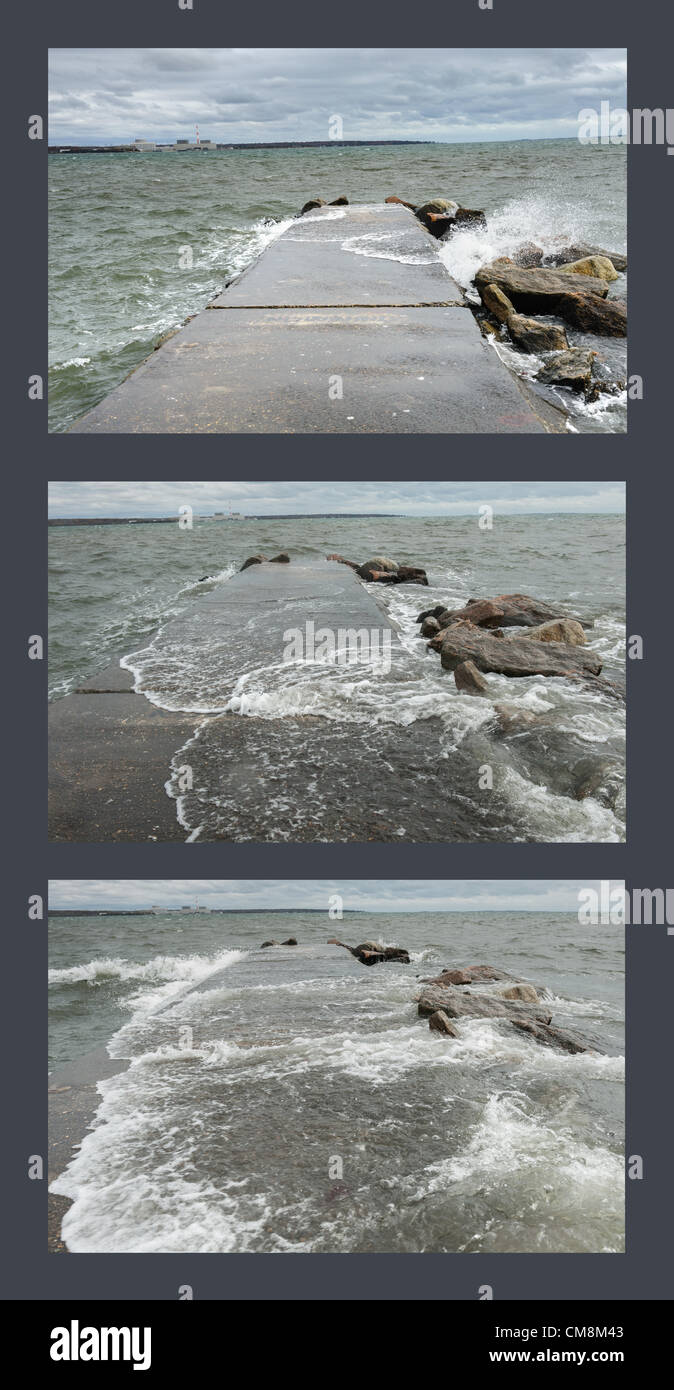 Niantic, East Lyme, Connecticut USA 28 Oct 2012 Wind, whitecaps and heavy surf build along the Connecticut shore the day before Hurricane Sandy hit. This series of three photos taken seconds apart shows how waves approach a jetty from both sides, eventually overrunning the pier located in the beach community of Black Point. Stock Photo