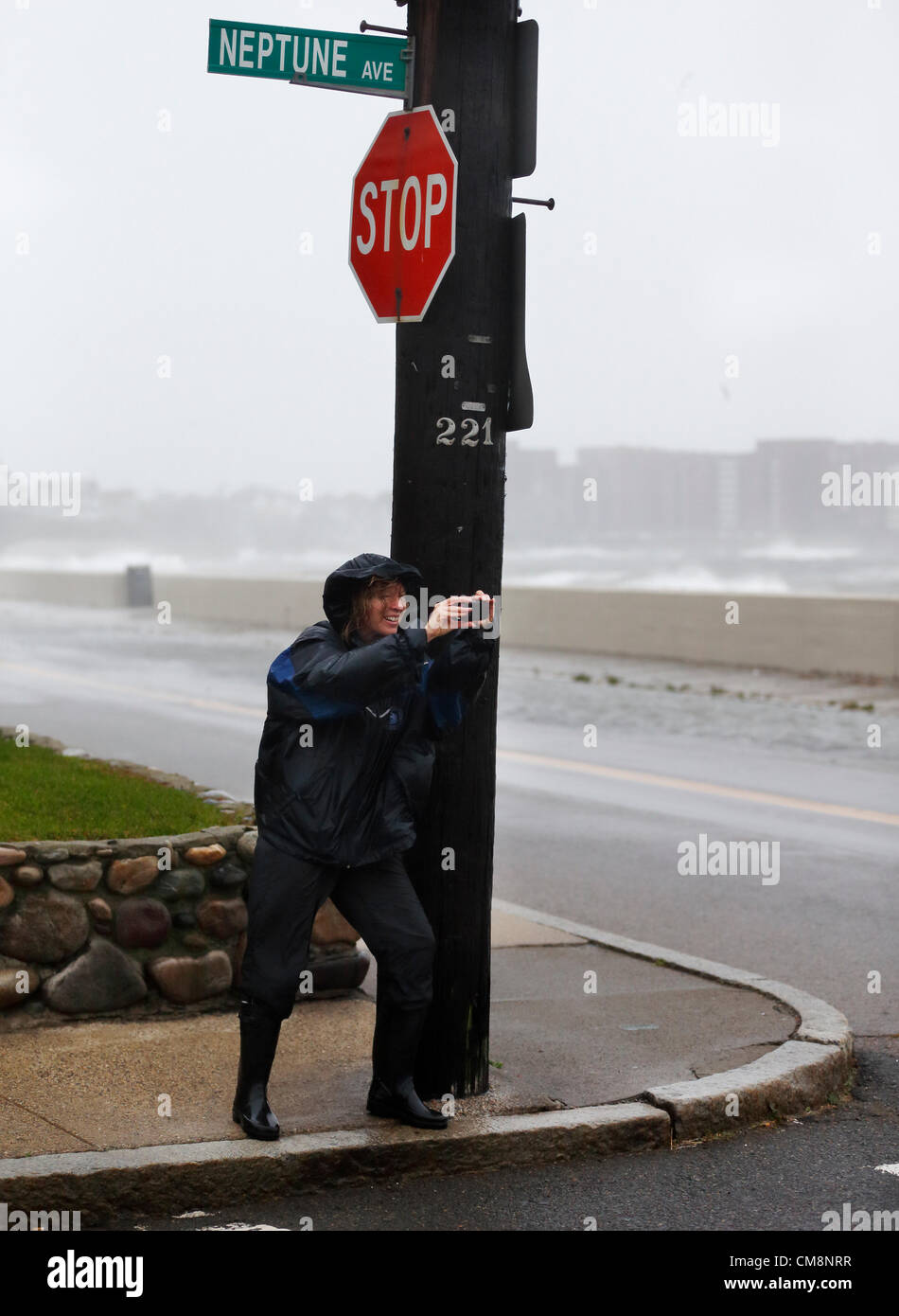 Winthrop, Massachusetts, USA. A woman braces herself against the wind