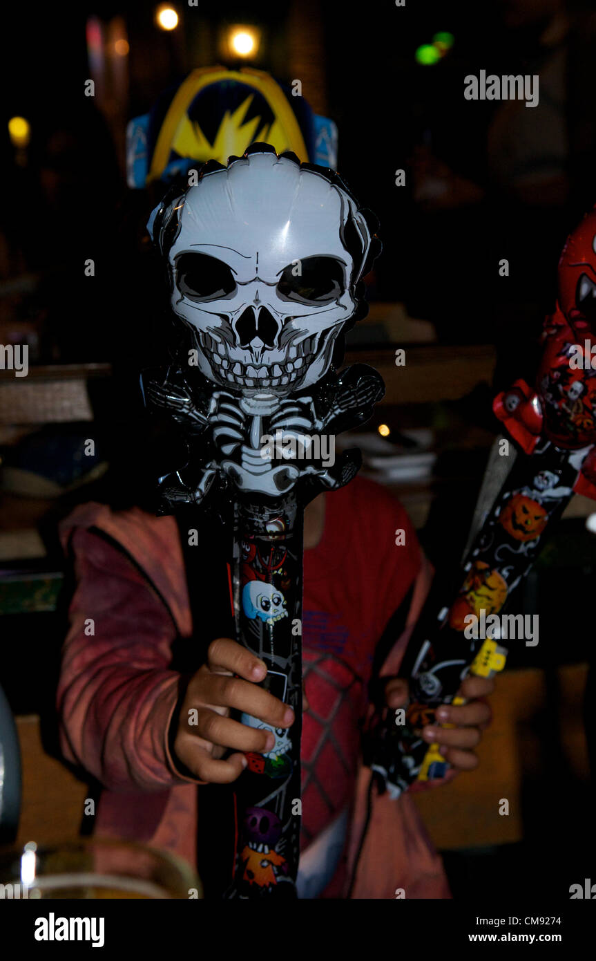 Bangkok, Thailand, 31/10/12 mixed race boy holds scary Halloween toys, Tawandang German brewery. Stock Photo
