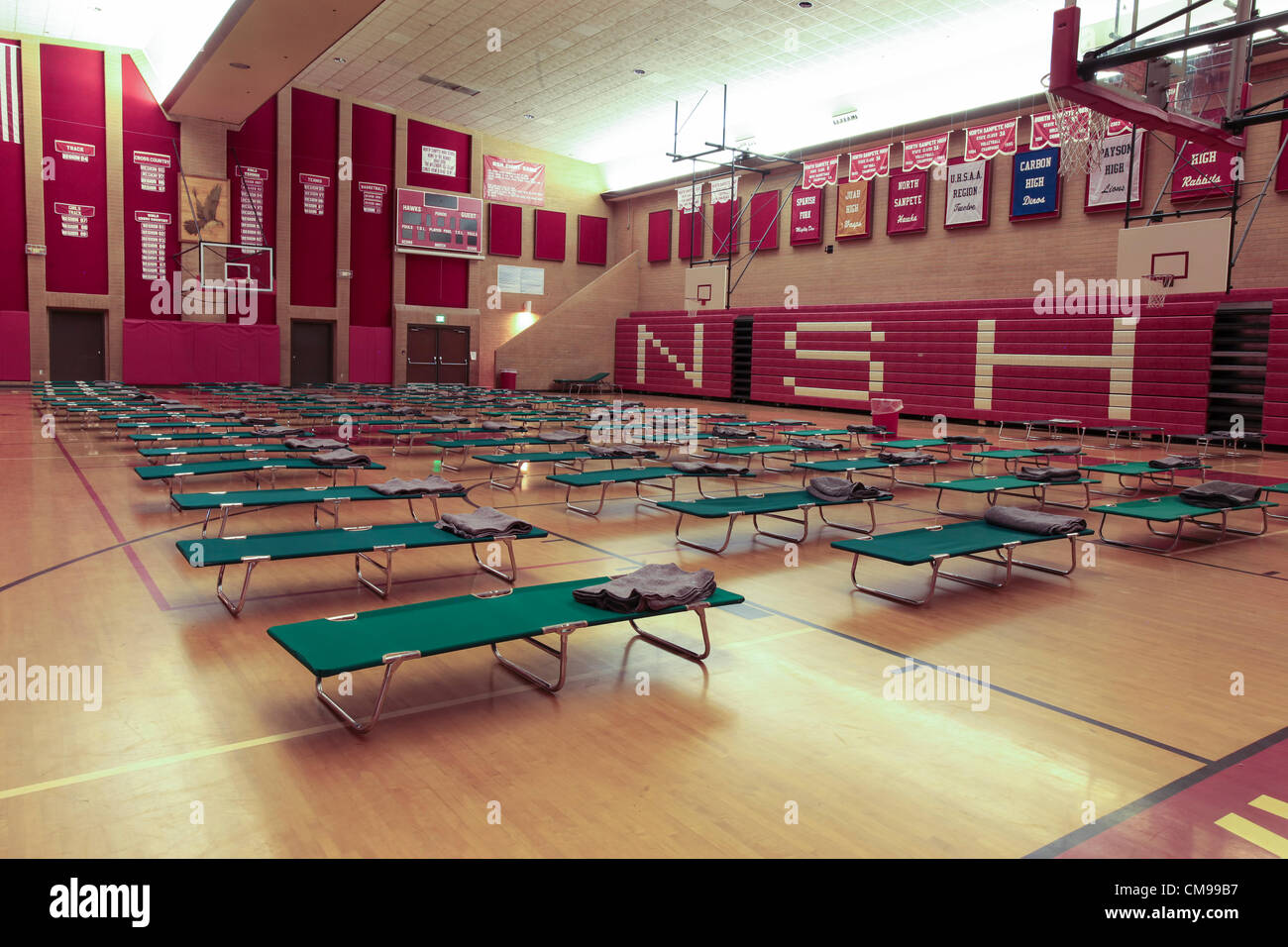 Mount Pleasant, Sanpete County, Utah USA 26 June 2012. Red Cross shelter in high school. Cots and beds for evacuation. Forest wildfire destroys dozens of homes, over 50,000 acres and at least one death by burning. Fire fighters responded from across Utah and several western states to help rescue and extinquish the blaze. Several cities evacuated due to approaching dangers. Briefing before fighting the fire. Destroyed mountain landscape and homes. Largest fire so far this year in Utah. Millions of dollars cost. Stock Photo