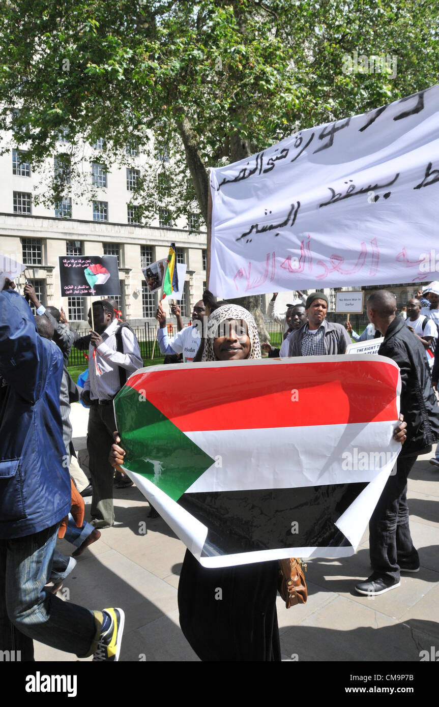 Whitehall, London, UK. 30th June 2012. A woman holds a Sudanese flag as Sudanese people demonstrate against their government opposite Downing Street in central London. Stock Photo