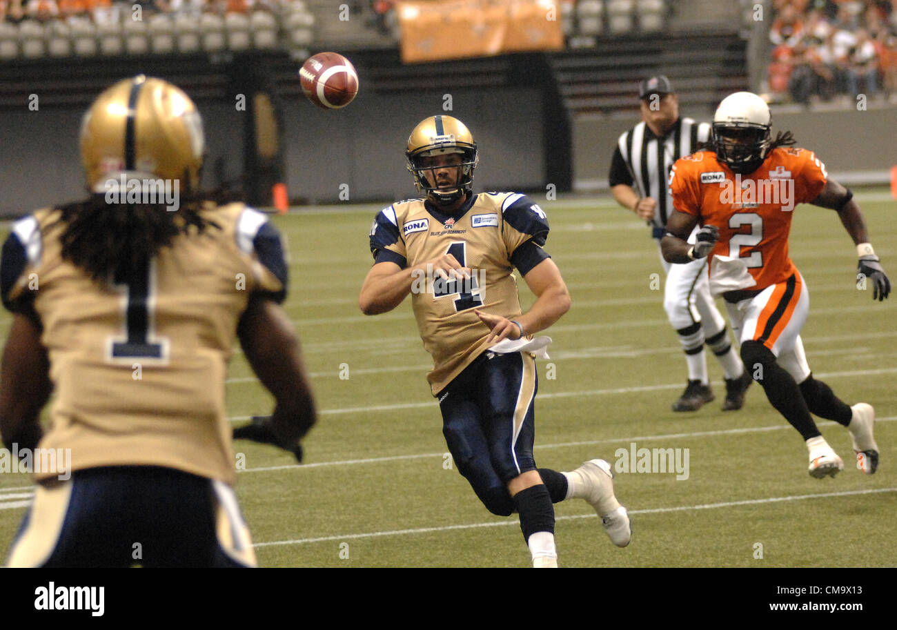 Winnipeg Blue Bombers’ quarterback Buck Pierce (C) passes against BC Lions during a CFL season opening football game in Vancouver, B.C., on June 29, 2012. Lions defeated Blue Bombers 44-10. Tonight BC Lions Geroy Simon made a history by breaking the CFL all-time receiving yards record in game against Winnipeg Blue Bombers. Stock Photo