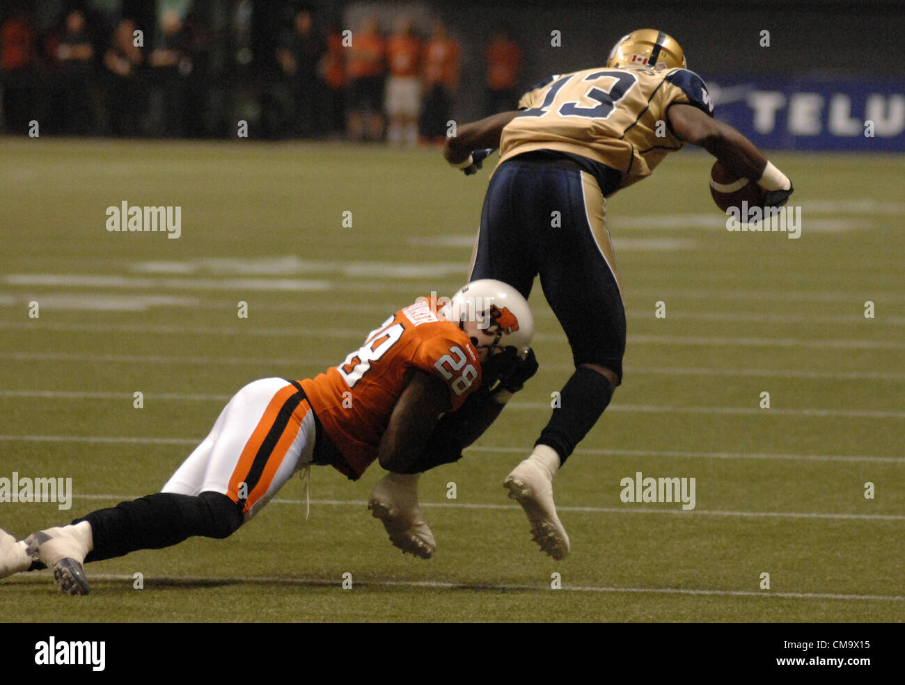 B.C. Lions’  Anthony Reddick (L) vies with Winnipeg Blue Bombers’ Chris Matthews during a CFL season opening football game in Vancouver, B.C., on June 29, 2012. Lions defeated Blue Bombers 44-10. Tonight BC Lions Geroy Simon made a history by breaking the CFL all-time receiving yards record in game against Winnipeg Blue Bombers. Stock Photo