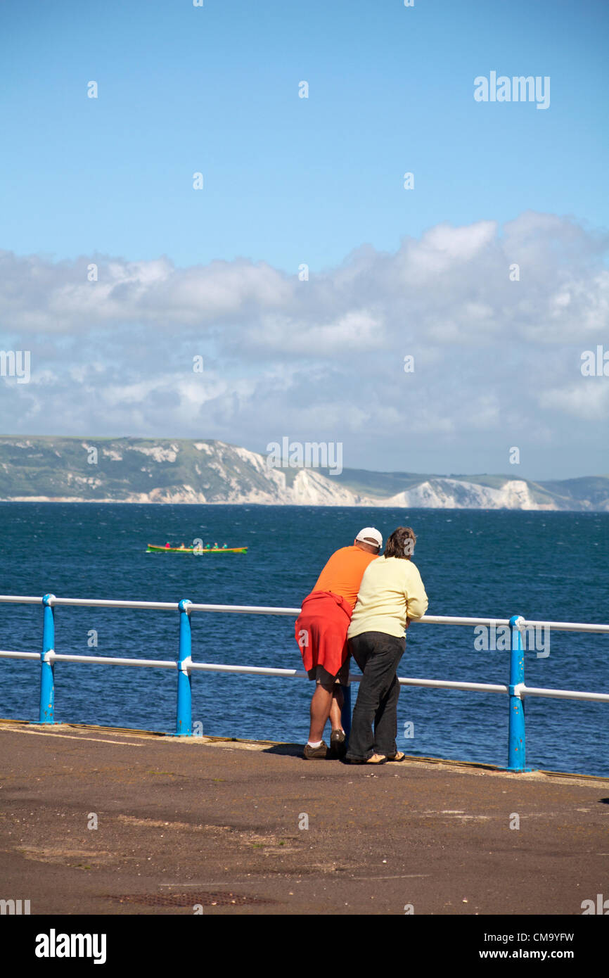 Weymouth, Dorset UK Saturday 30 June 2012. Weymouth Rowing Regatta - teams competing in Cornish Pilot Gigs. Couple watching the racing from the pier. Stock Photo