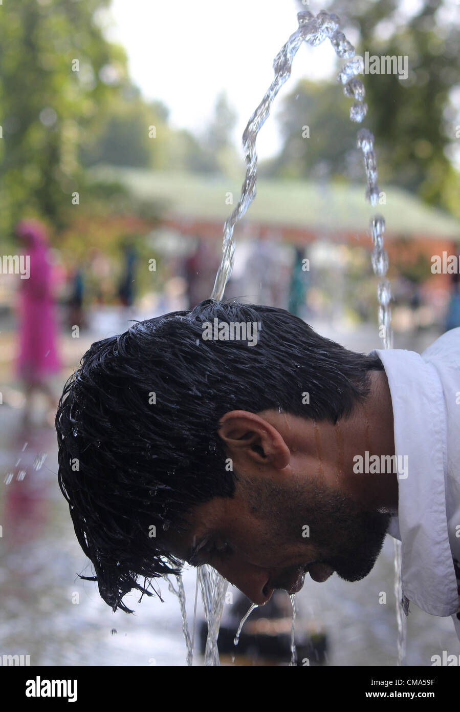 A kashmiri muslim hold  head with fountains  during hot day in srinagar, the summer capiatl of indian kashmir on 1,7,2012 Photo/Altaf Zargar/Zuma Press Stock Photo