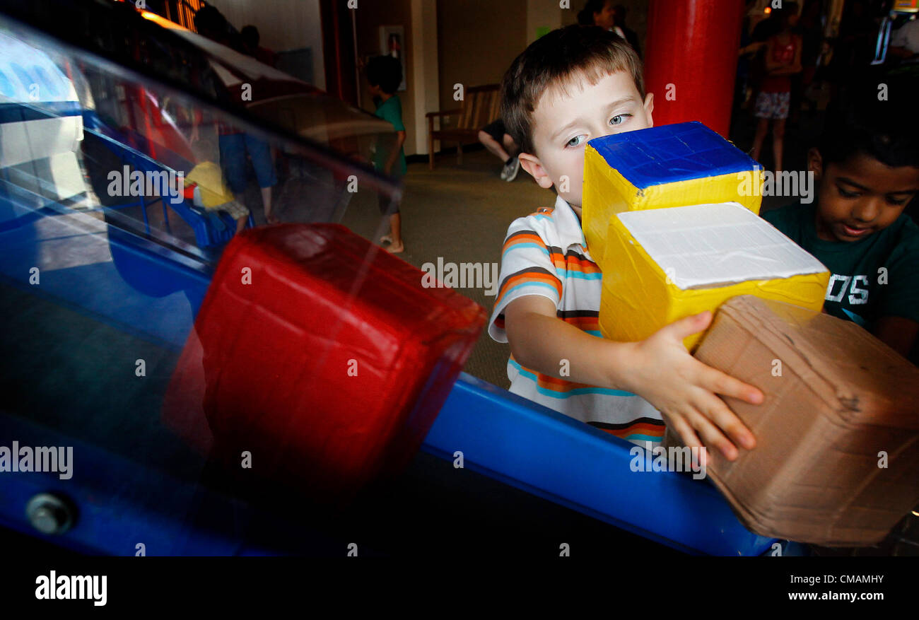 July 5, 2012 - Memphis, TN, U.S. - July 5, 2012 - Owen Siller, 6, of Akworth, Ga., places boxes on a conveyor system at the The Children's Museum of Memphis Thursday afternoon. Last year CMOM received a grant from FedEx to fund an overhaul of the exhibit area.  A conveyor system, package counter and display screen were installed as part of this grant.  The new exhibit components opened at the end of October and in just eight months, children have already reached the 500,000 packages loaded into the plane. (Credit Image: © Mark Weber/The Commercial Appeal/ZUMAPRESS.com) Stock Photo