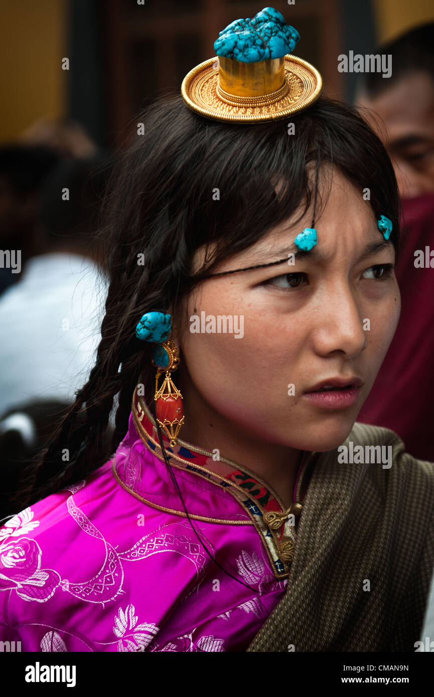 July 6, 2012 - Kathmandu, Kathmandu, Nepal - A Tibetan refugee girl dressed in traditional Tibetan costume attends birthday celebration of his holiness Dalai Lama on the grounds of Chugsamon temple. Exiled Tibetans in Nepal were banned from observing His Holiness' birthday; few hundred Tibetans gathered in Chugsamon temple in Kathmandu to observe birthday ceremony organized by exiled Tibetans despite heavy security forces being dispatched. Nepal government fears that Tibetan ceremonies and observances can lead to anti-Chinese protests.  Stock Photo