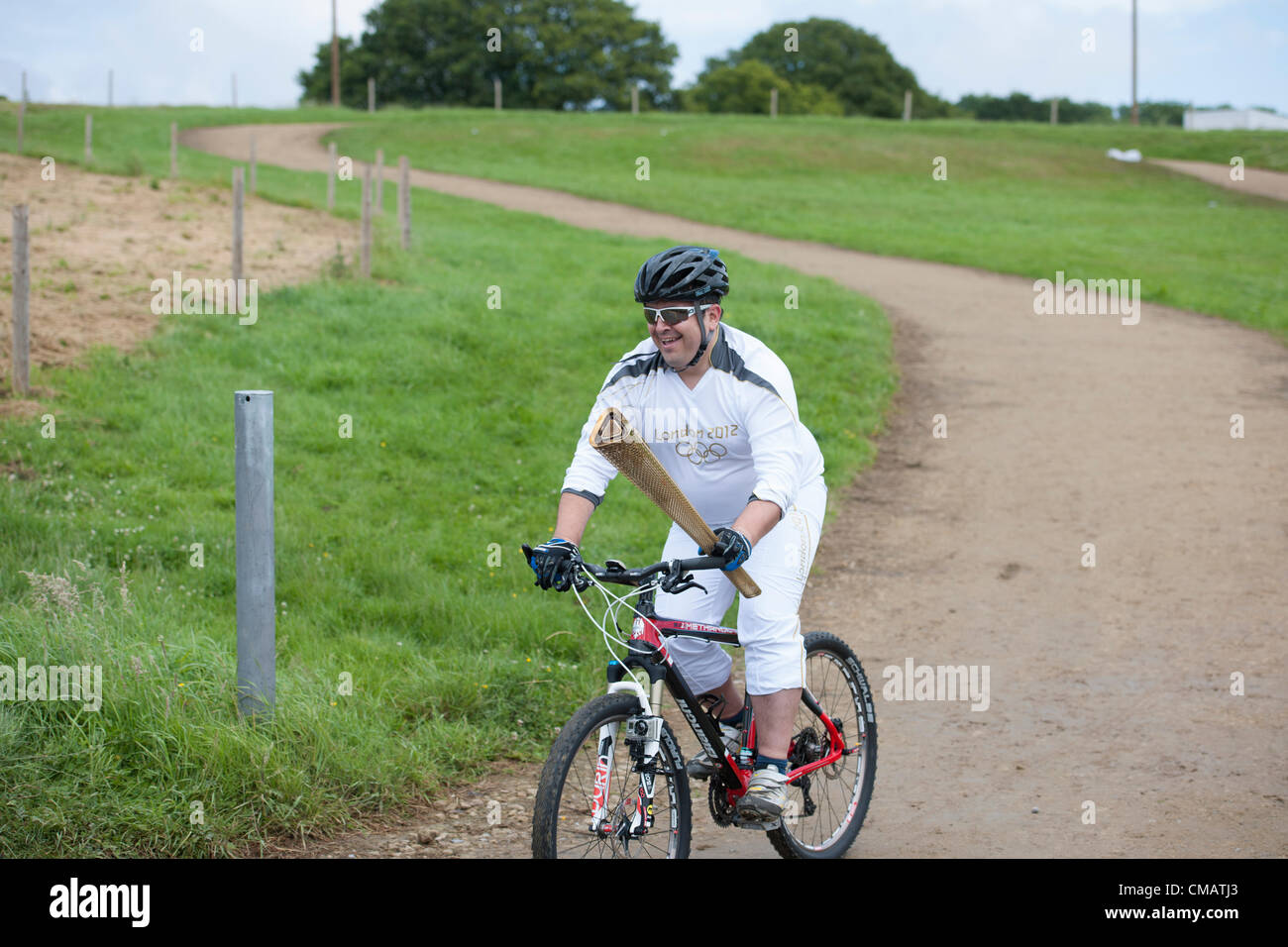 6th July 2012. Hadleigh Farm, Hadleigh,Essex,UK. The Olympic Torch relay visited the mountain bike course at Hadleigh Farm in the south of Essex. Dan Jarvis carried the torch on a short loop of the course before handing over to the next runner, Kim Axford. Stock Photo