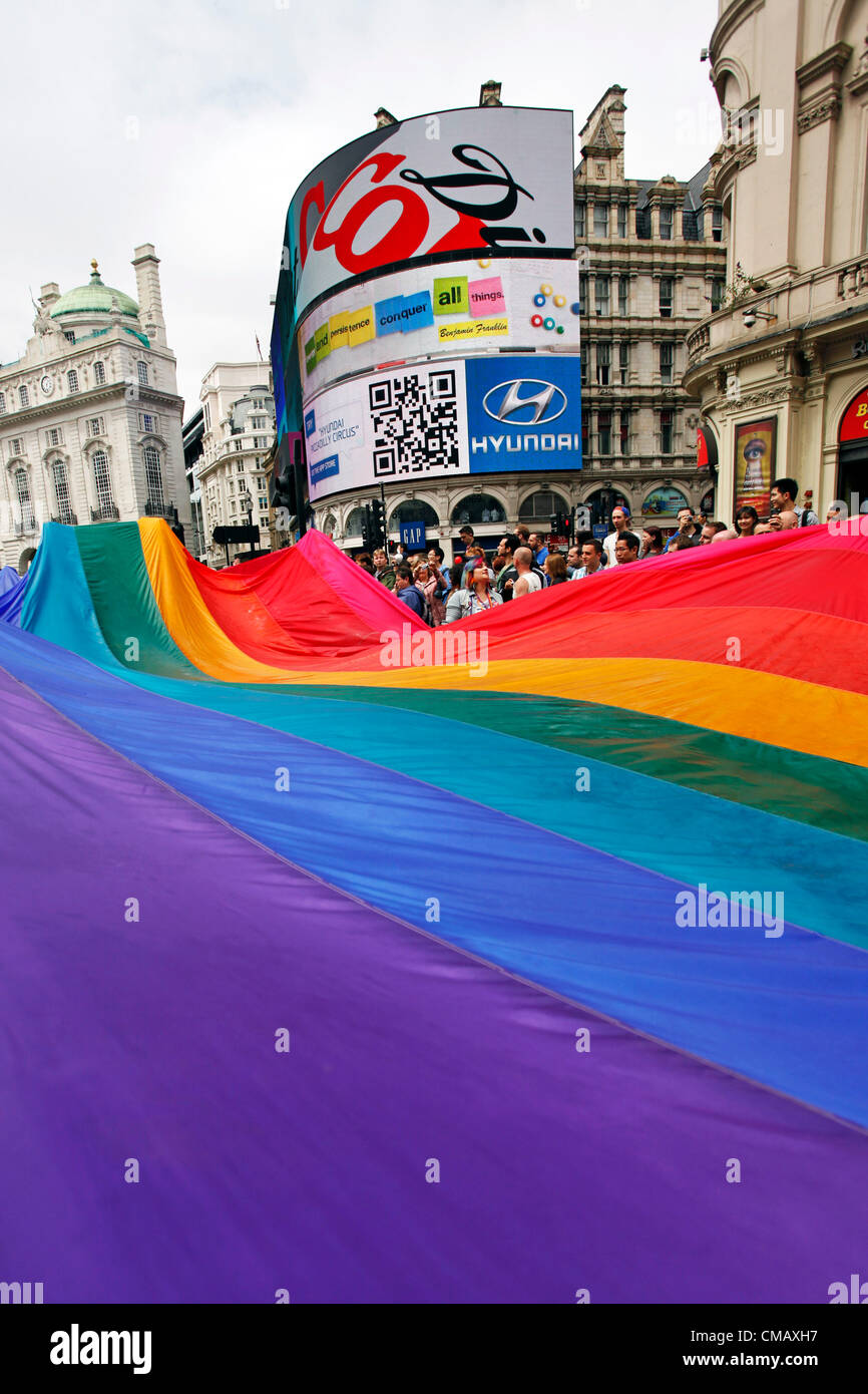 London, UK. 7th July 2012. The rainbow flag at Piccadilly Circus and participants marching in World Pride 2012, London, England Stock Photo