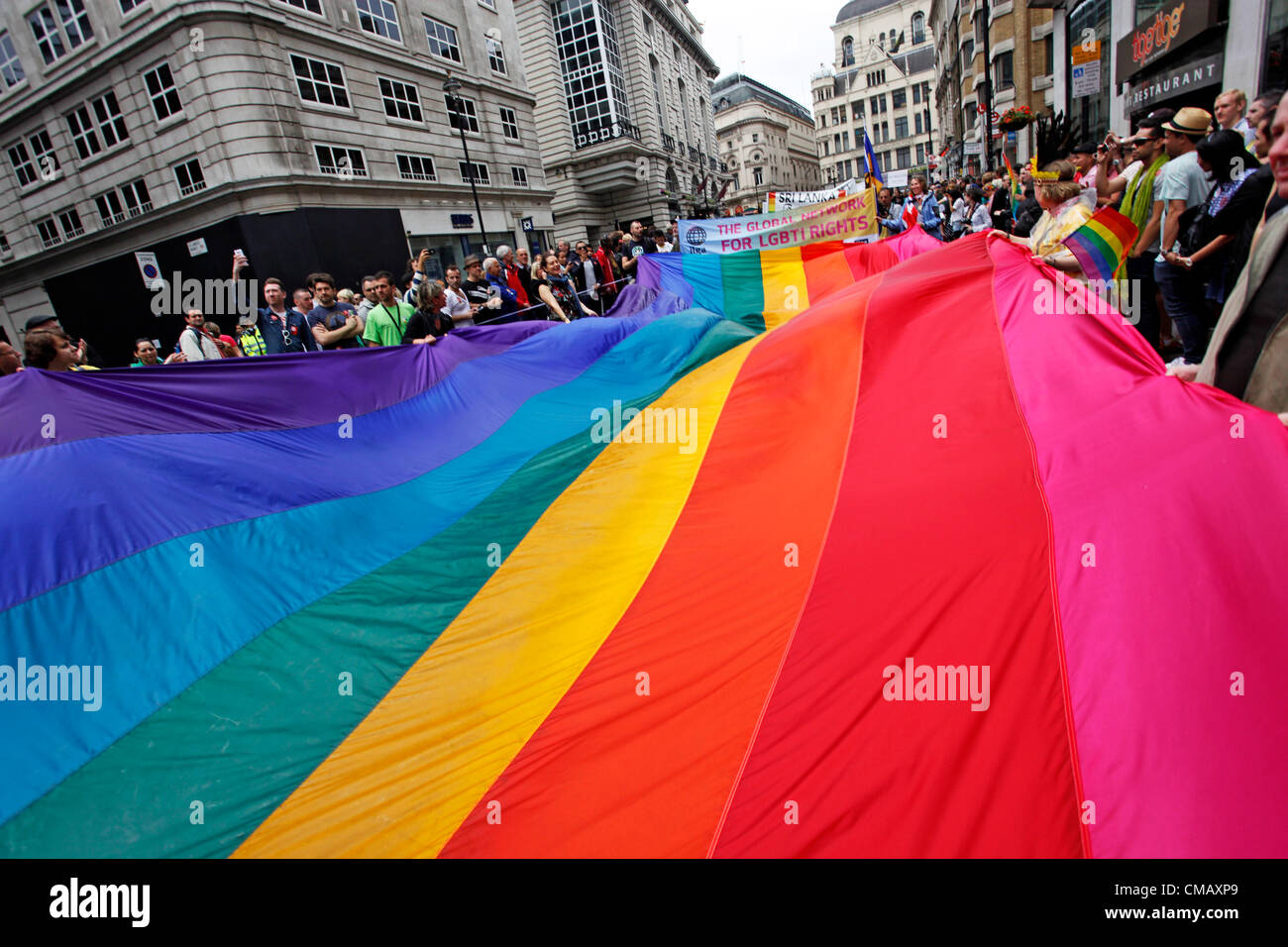 London, UK. 7th July 2012. The rainbow flag and participants marching in World Pride 2012, London, England Stock Photo