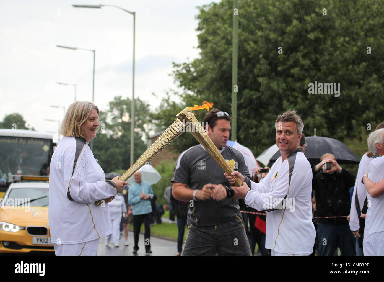 Hemel Hempstead, UK. 8 July, 2012. The flame is transferred from one torch to another on day 50 of the Olympic torch relay in Hemel Hempstead Stock Photo